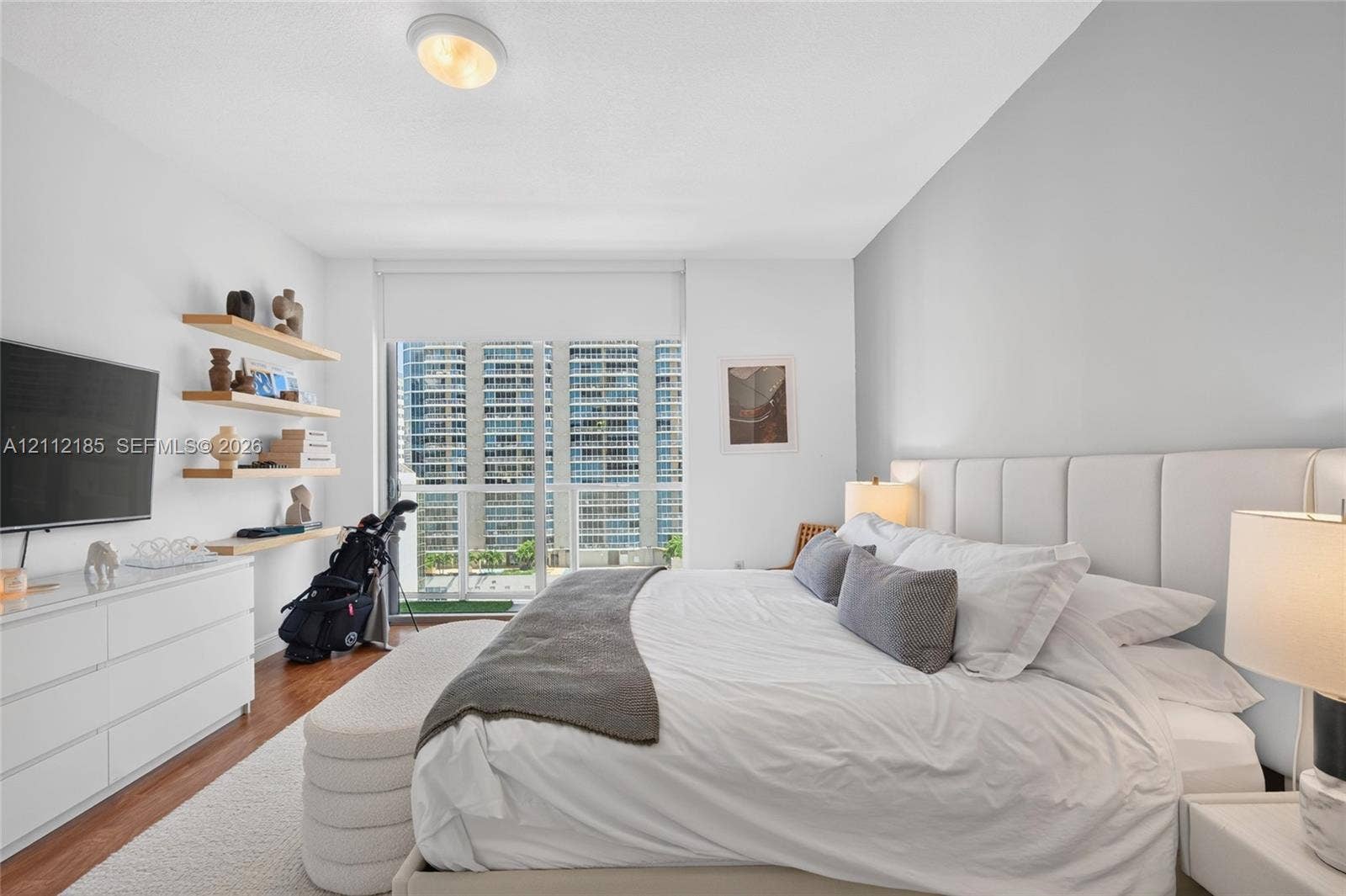 1060 Brickell Avenue, #2401, Miami, FL 33131 Wood-finish flooring, floor-to-ceiling windows with roller shades, and custom built-in floating shelving