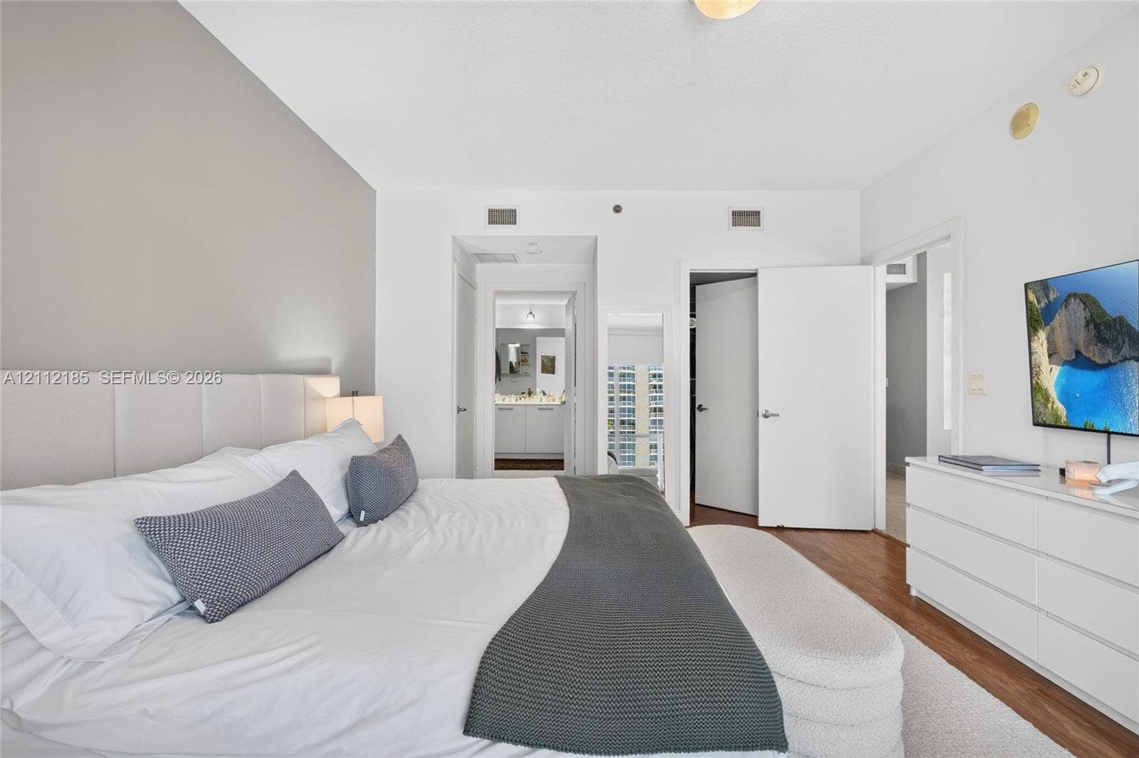 1060 Brickell Avenue, #2401, Miami, FL 33131 Neutral interior featuring wood-finish flooring, a charcoal gray accent wall, and solid-core interior doors