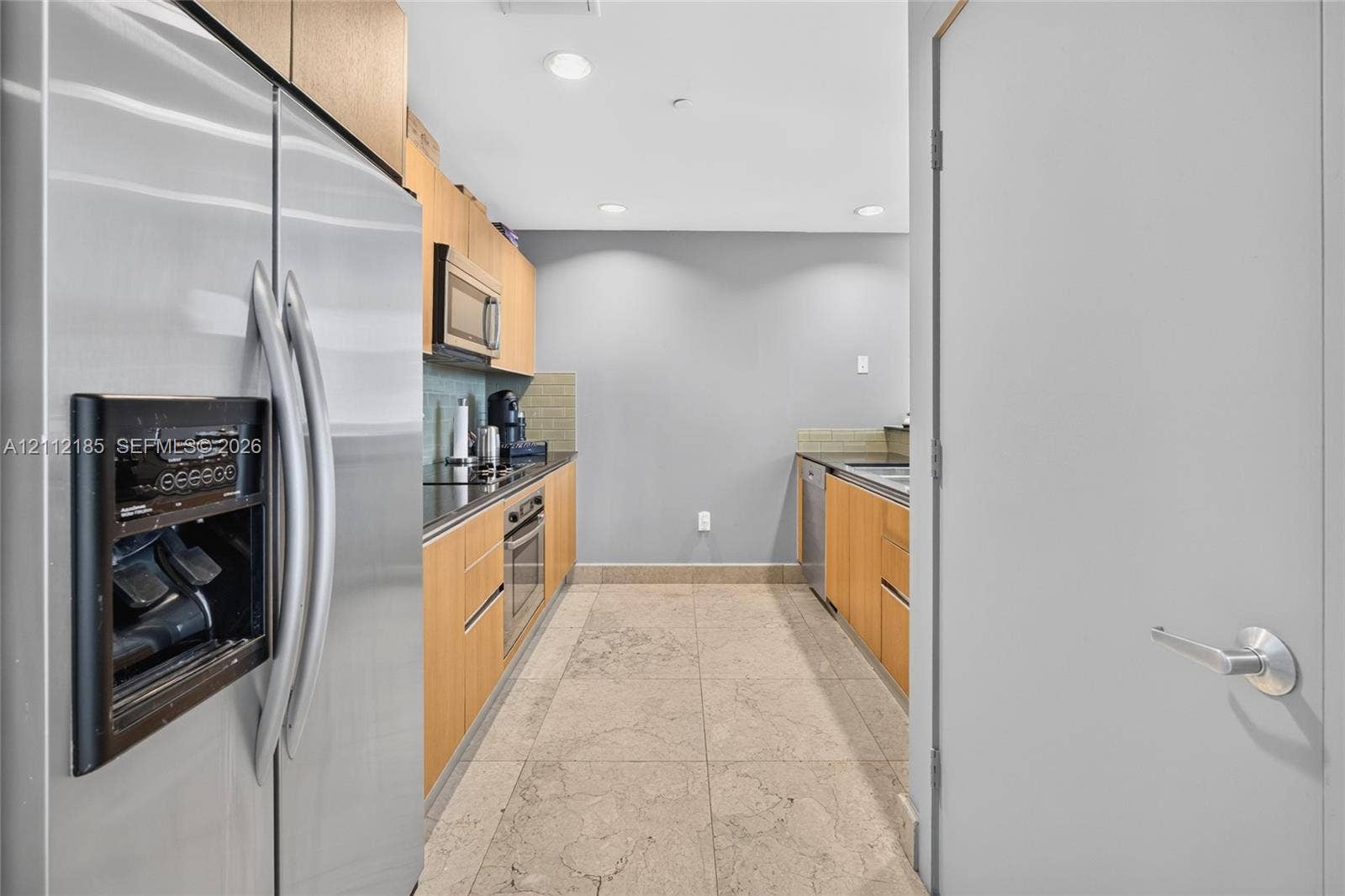 1060 Brickell Avenue, #2401, Miami, FL 33131 Kitchen featuring flat-panel wood cabinetry, stone flooring, stainless steel side-by-side refrigerator, built-in microwave, and recessed lighting