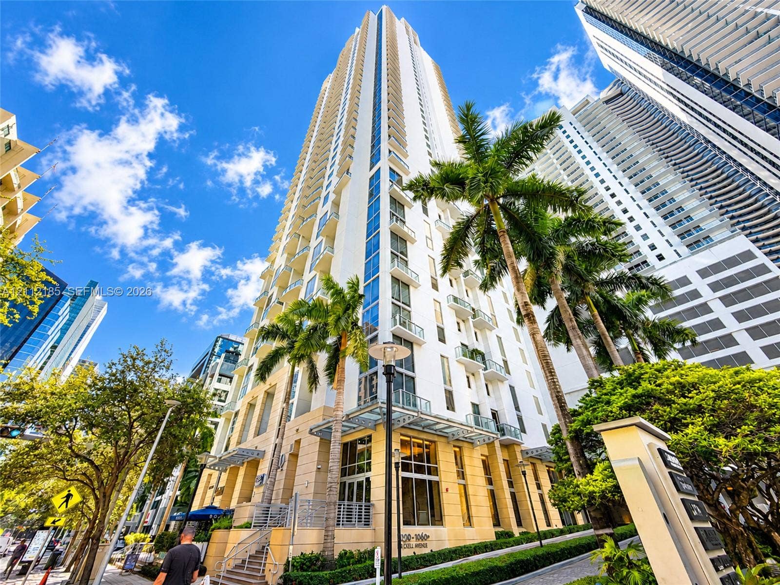 1060 Brickell Avenue, #2401, Miami, FL 33131 High-rise exterior featuring glass-railed balconies, expansive window arrays, stone-clad facade elements, and tiered architectural detailing
