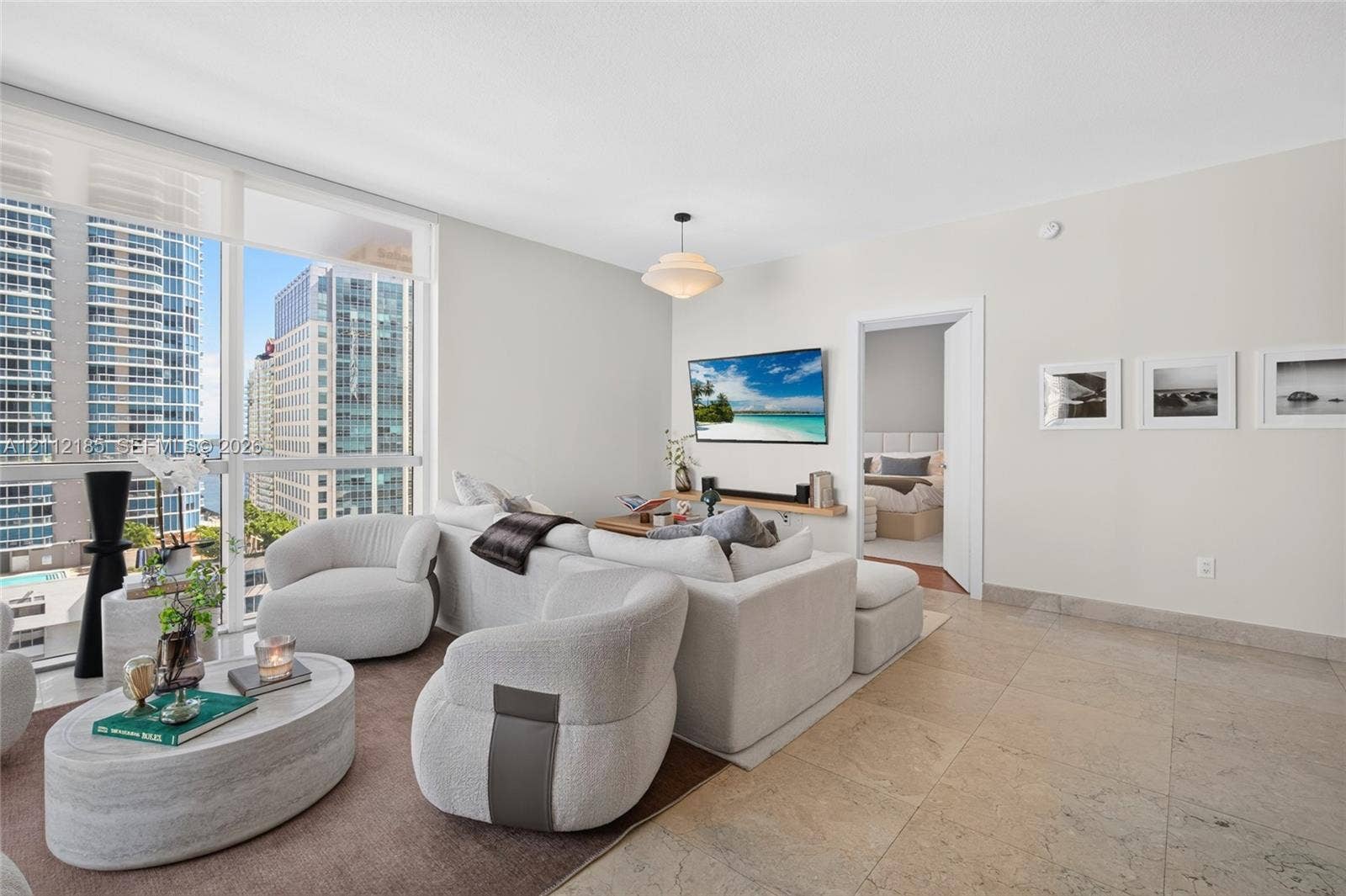 1060 Brickell Avenue, #2401, Miami, FL 33131 Floor-to-ceiling windows, large-format tile flooring, and a central pendant light fixture