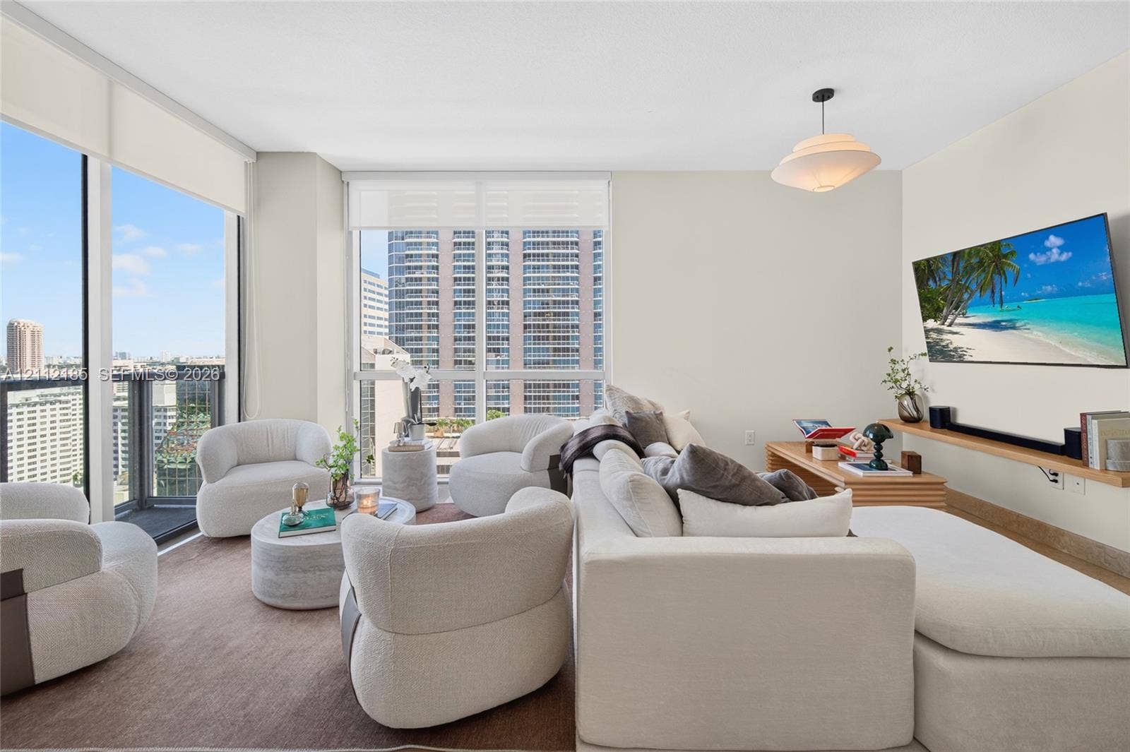 1060 Brickell Avenue, #2401, Miami, FL 33131 Living area featuring floor-to-ceiling windows, natural light, a wall-mounted wooden shelf, and a pendant light fixture