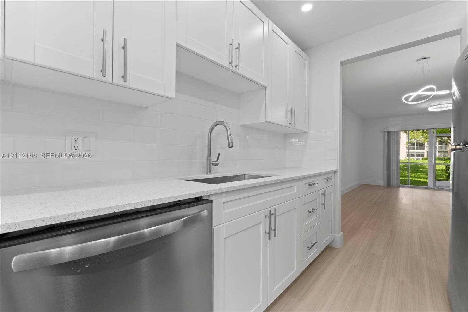 1300 SW 124th Terrace, #107P, Pembroke Pines, Pembroke Pines, FL 33027 Kitchen featuring white shaker-style cabinetry, quartz countertops, subway tile backsplash, stainless steel appliances, and wood-finish flooring
