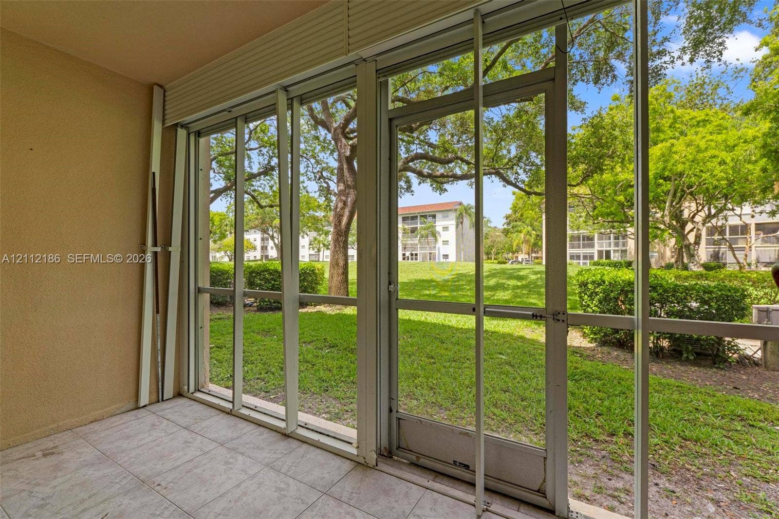 1300 SW 124th Terrace, #107P, Pembroke Pines, Pembroke Pines, FL 33027 Enclosed patio featuring floor-to-ceiling screen panels, a metal-framed screen door, and ceramic tile flooring