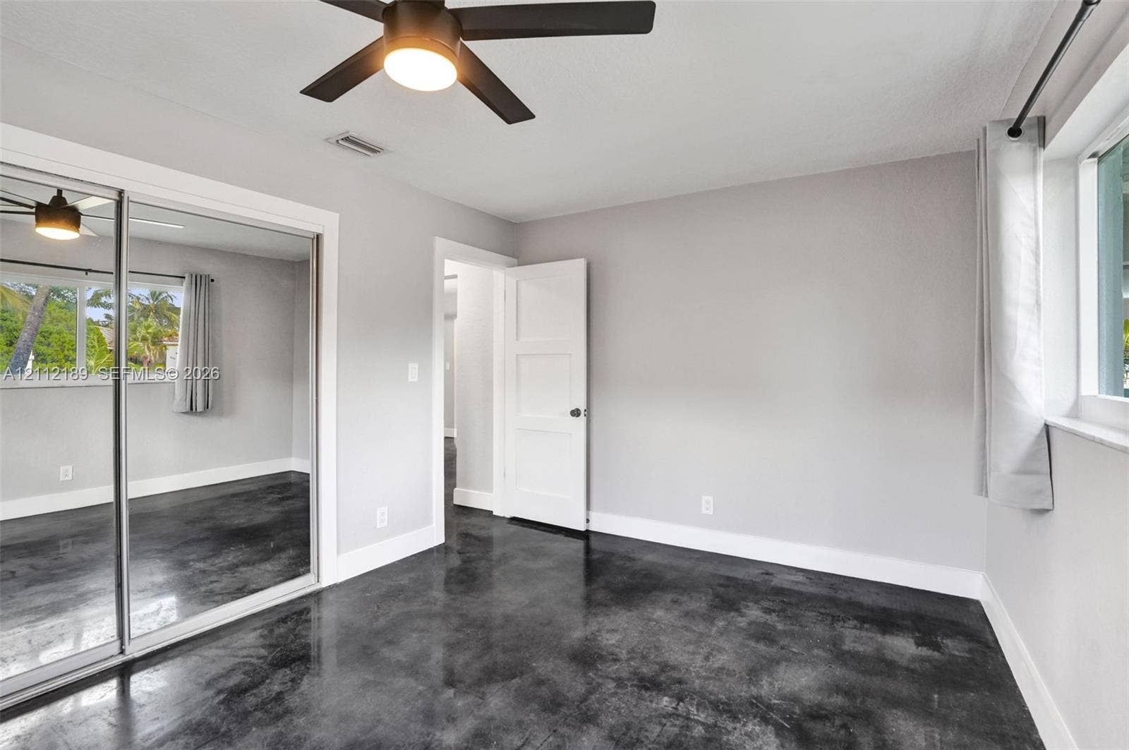 5161 SW 7th Court, #0, Margate, Margate, FL 33068 Polished concrete flooring, floor-to-ceiling mirrored sliding closet doors, and a modern ceiling fan with integrated lighting