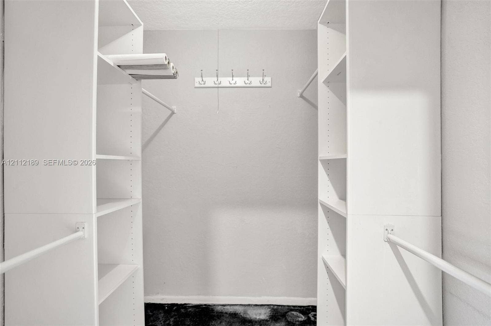 5161 SW 7th Court, #0, Margate, Margate, FL 33068 Walk-in closet featuring dual floor-to-ceiling built-in white shelving units, horizontal hanging rods, and a wall-mounted hook rack