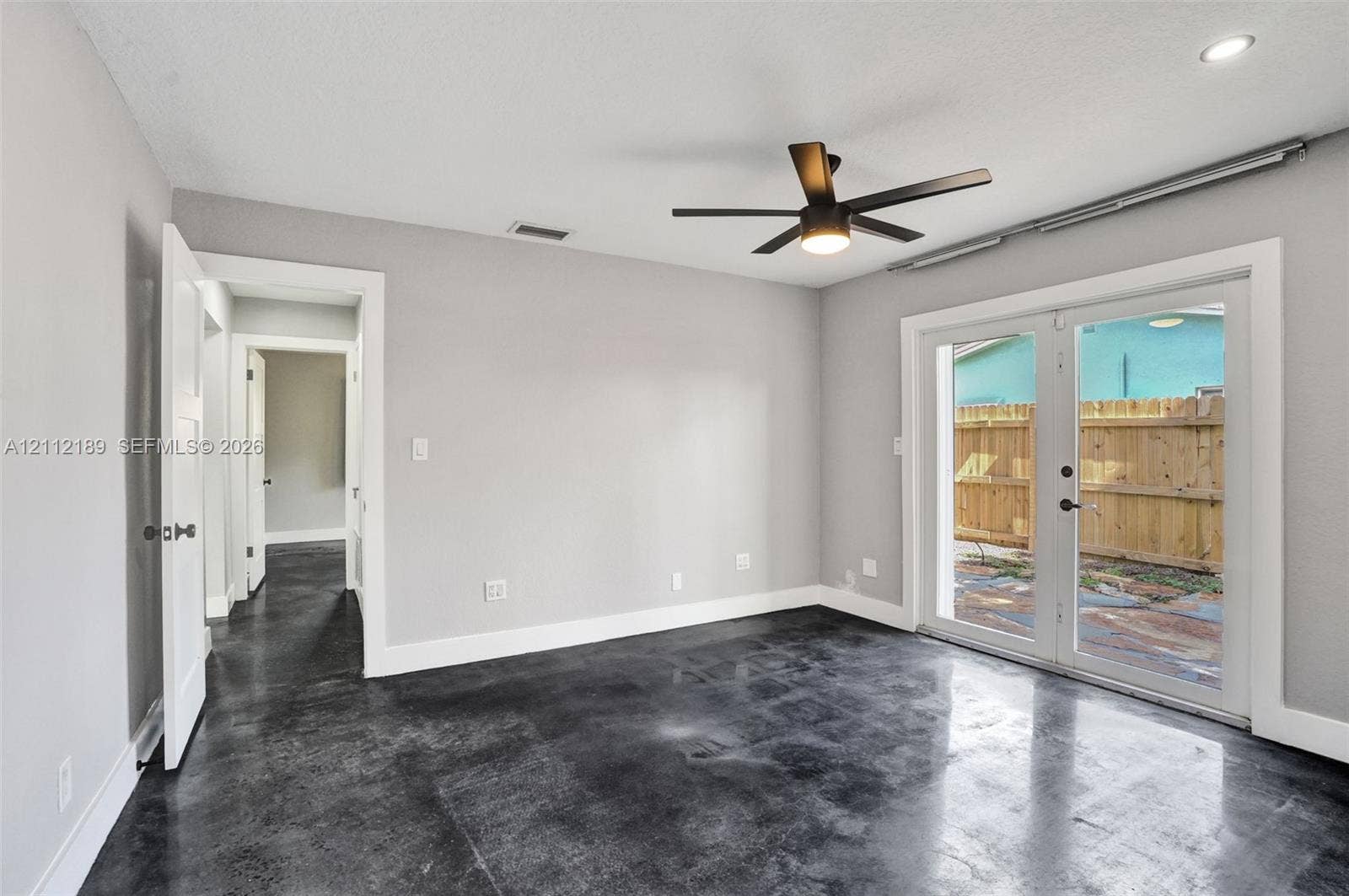 5161 SW 7th Court, #0, Margate, Margate, FL 33068 Polished concrete flooring, recessed lighting, matte black ceiling fan, and double glass doors featuring white trim