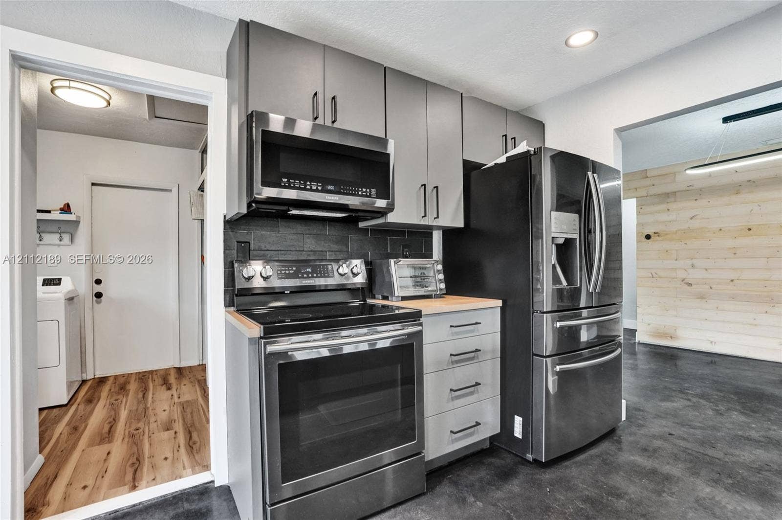 5161 SW 7th Court, #0, Margate, Margate, FL 33068 Kitchen featuring gray slab-front cabinetry, stainless steel appliances, a dark stone-finish backsplash, wood-surface countertops, and recessed lighting