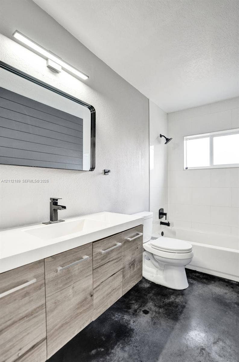 5161 SW 7th Court, #0, Margate, Margate, FL 33068 Bathroom featuring a floating wood-finish vanity with an integrated basin, matte black wall-mounted fixtures, rectangular-framed mirror, and tub-shower combination with tiled surround