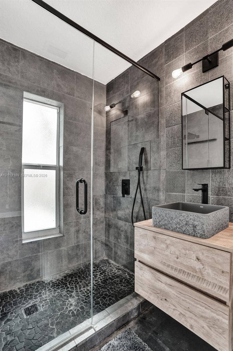 5161 SW 7th Court, #0, Margate, Margate, FL 33068 Walk-in shower featuring glass paneling, floor-to-ceiling gray tile, and a pebble-stone basin