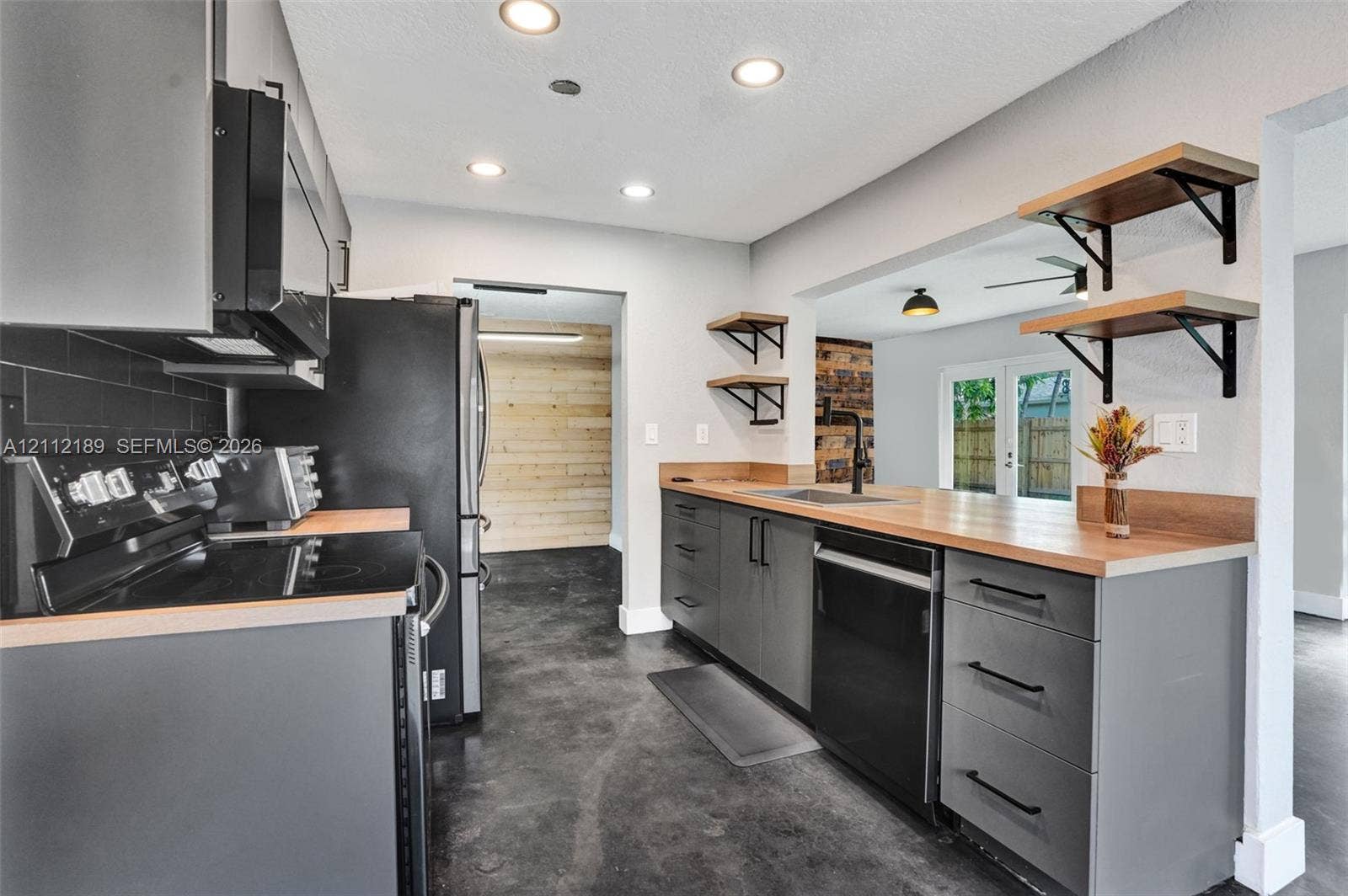 5161 SW 7th Court, #0, Margate, Margate, FL 33068 Kitchen featuring flat-panel charcoal cabinetry, wood-tone countertops, matte black hardware, recessed ceiling lighting, and open wall-mounted shelving