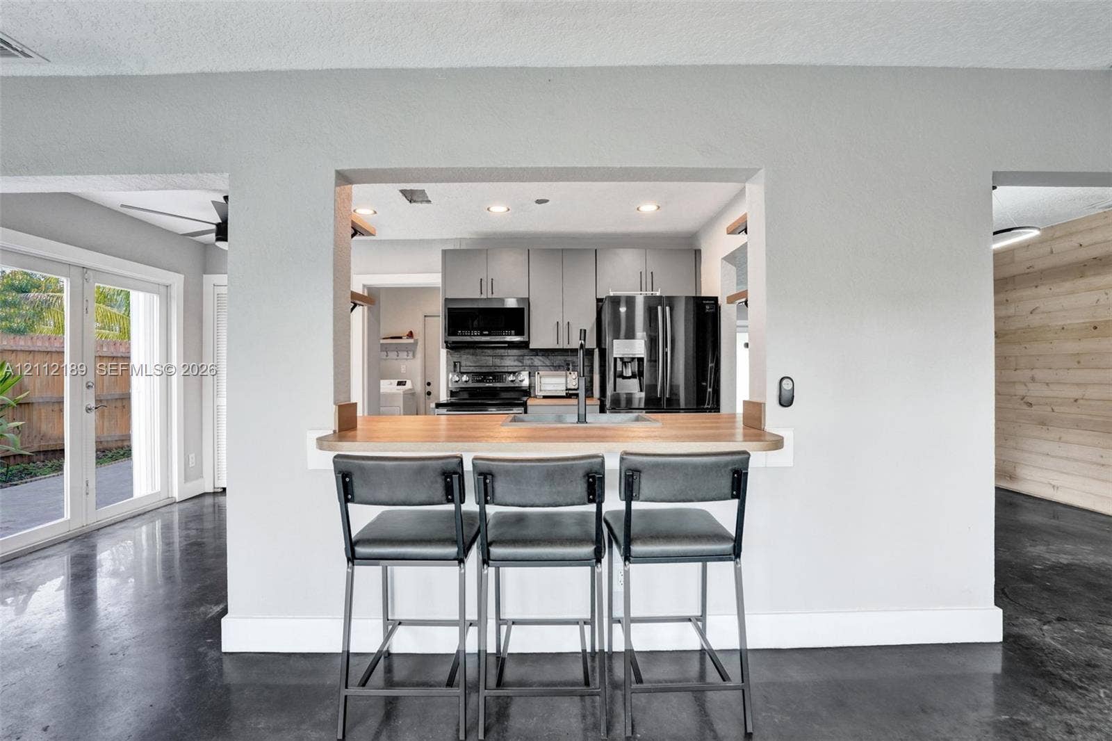 5161 SW 7th Court, #0, Margate, Margate, FL 33068 Kitchen featuring gray cabinetry, stainless steel appliances, a wood-finish countertop pass-through, and concrete flooring