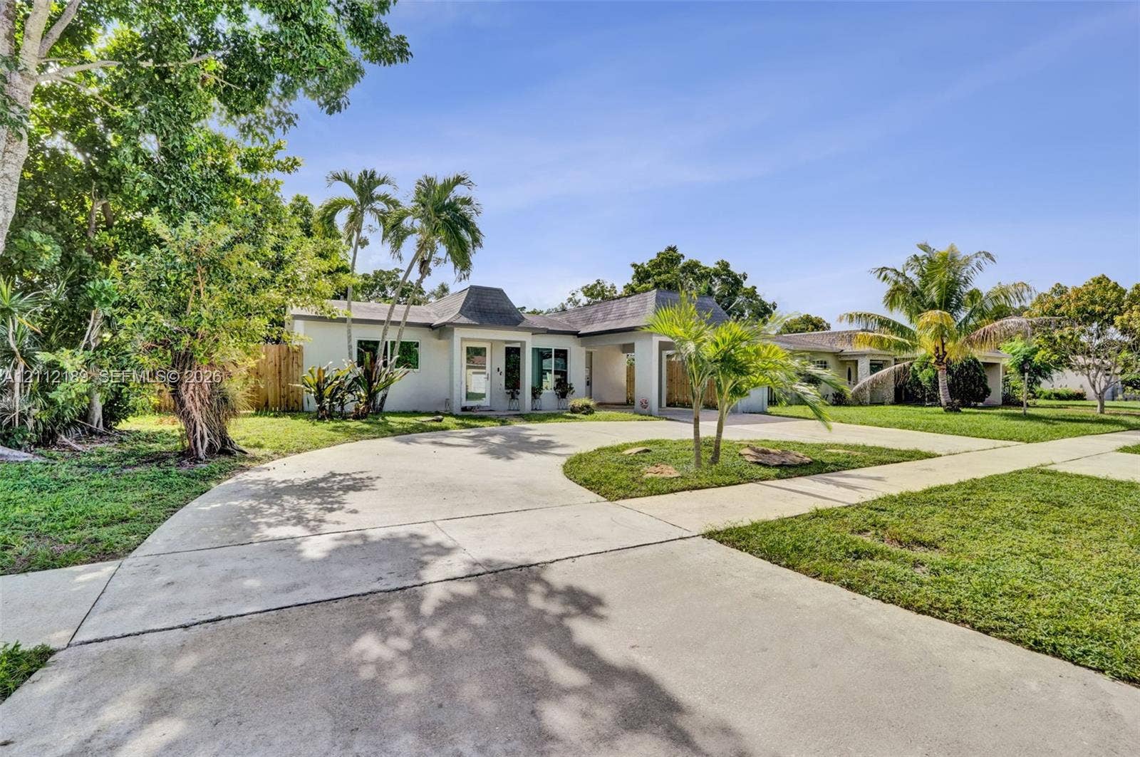 5161 SW 7th Court, #0, Margate, Margate, FL 33068 Single-story exterior featuring a hip roof, stucco facade, expansive concrete circular driveway, and mature landscaping