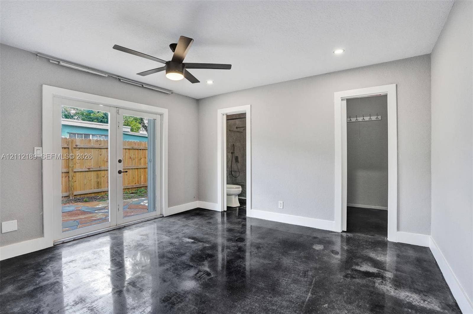 5161 SW 7th Court, #0, Margate, Margate, FL 33068 Polished concrete flooring, recessed ceiling lighting, matte black ceiling fan, and double glass-paned doors with exterior access