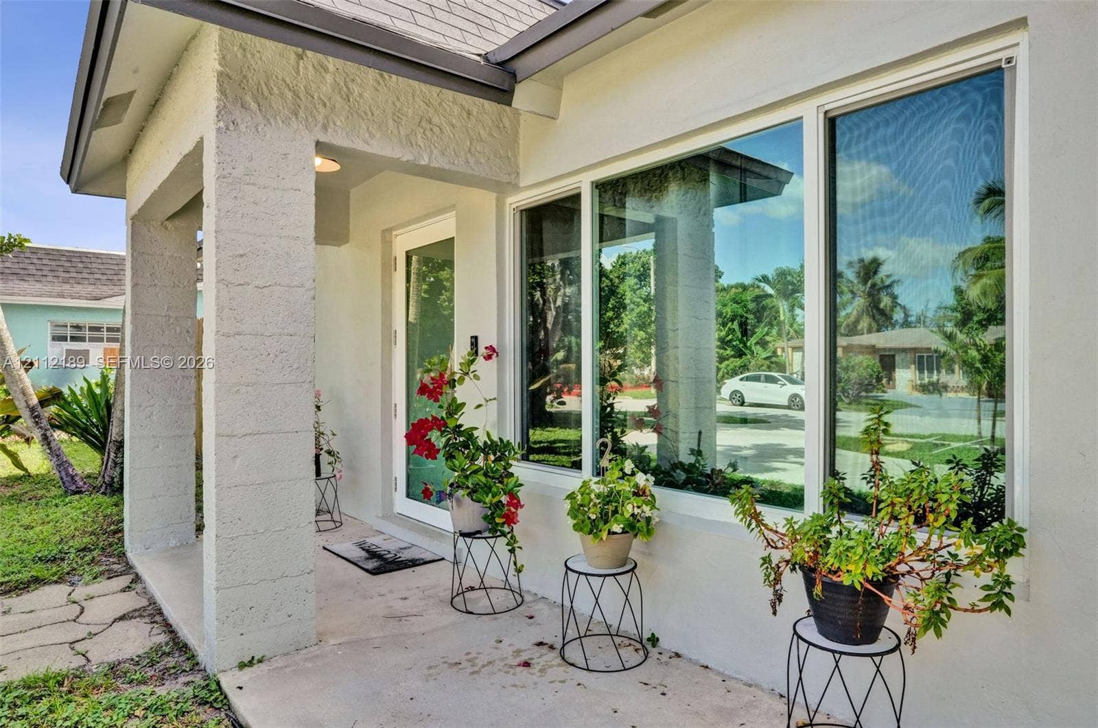 5161 SW 7th Court, #0, Margate, Margate, FL 33068 Covered entryway featuring textured masonry columns, oversized picture window, and full-lite glass entry door