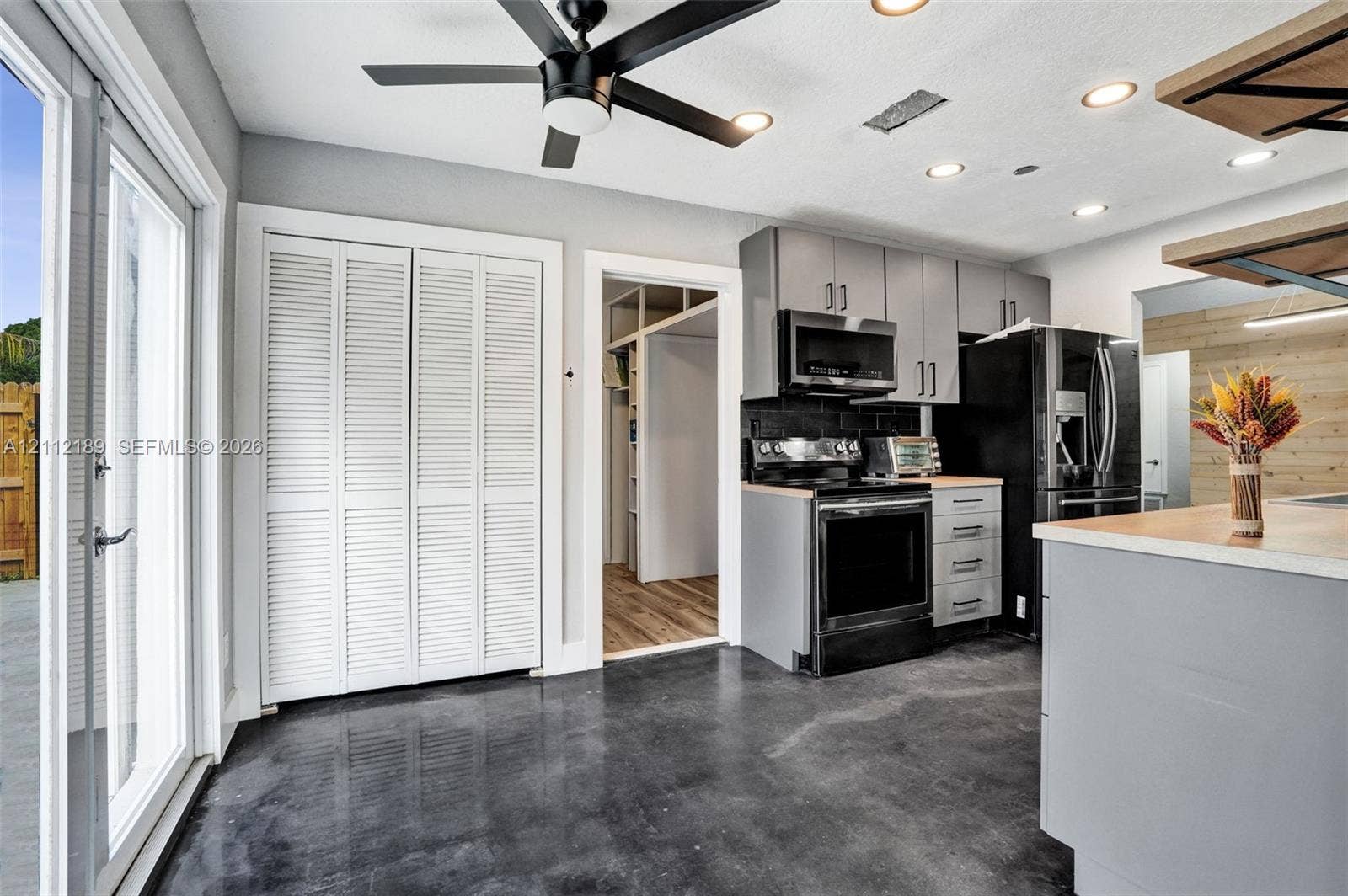 5161 SW 7th Court, #0, Margate, Margate, FL 33068 Kitchen featuring charcoal-toned cabinetry, stainless steel appliances, polished concrete flooring, a ceiling fan, and double glass patio doors