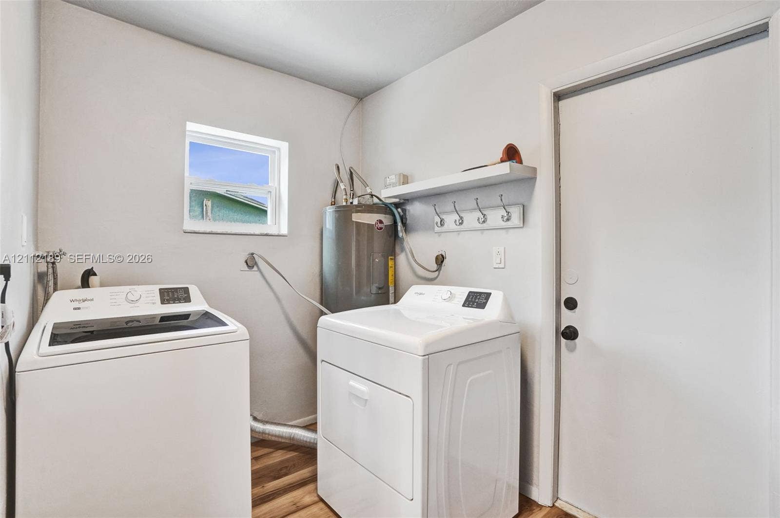 5161 SW 7th Court, #0, Margate, Margate, FL 33068 Utility space featuring wood-finish flooring, a wall-mounted shelf with integrated hooks, and a dedicated window