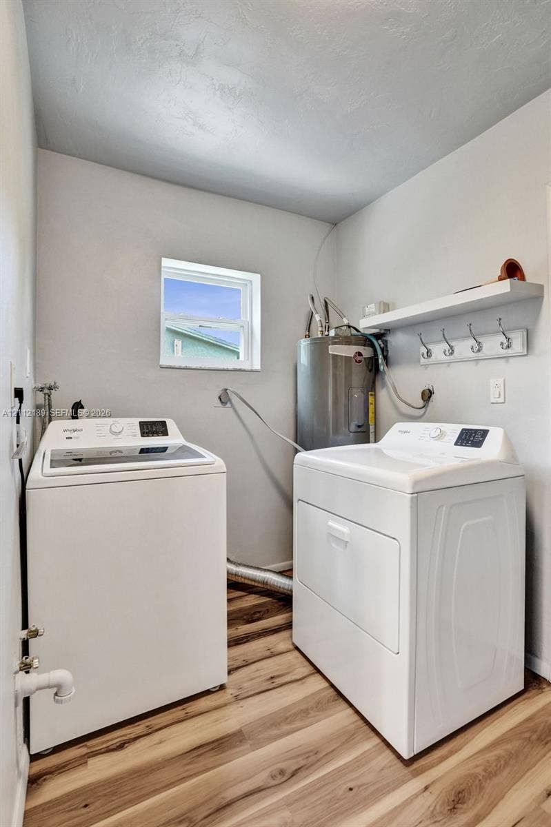 5161 SW 7th Court, #0, Margate, Margate, FL 33068 Laundry area featuring wood-finish flooring, a built-in wall shelf with a row of coat hooks, and a dedicated water heater