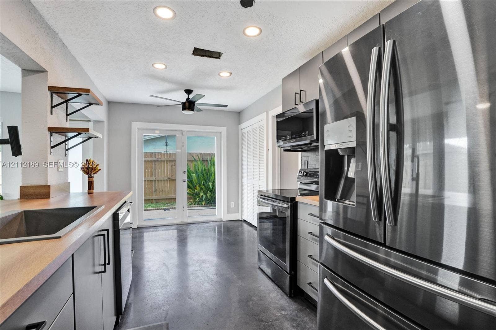 5161 SW 7th Court, #0, Margate, Margate, FL 33068 Kitchen featuring stainless steel appliances, wood-finish countertops, recessed lighting, concrete flooring, and glass-paned doors