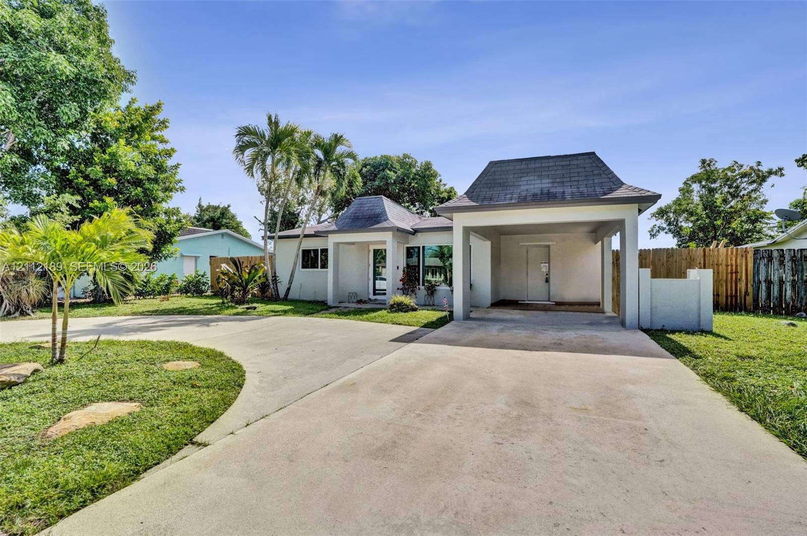 5161 SW 7th Court, #0, Margate, Margate, FL 33068 Single-story exterior featuring a hip roof, expansive concrete driveway, covered porte-cochre, and mature palm landscaping