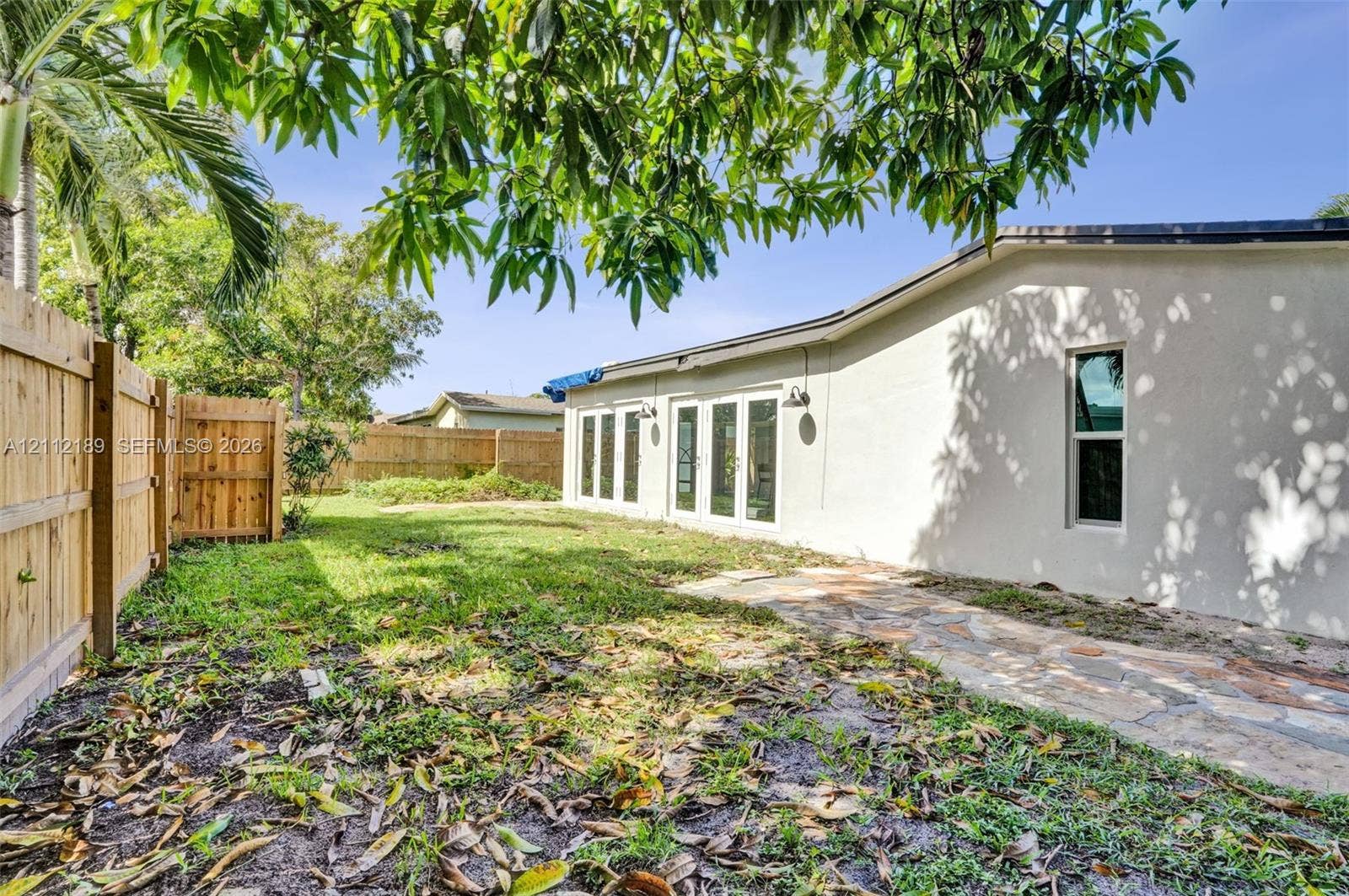 5161 SW 7th Court, #0, Margate, Margate, FL 33068 Fenced backyard featuring stone paver hardscaping and multiple sets of exterior glass-paneled doors