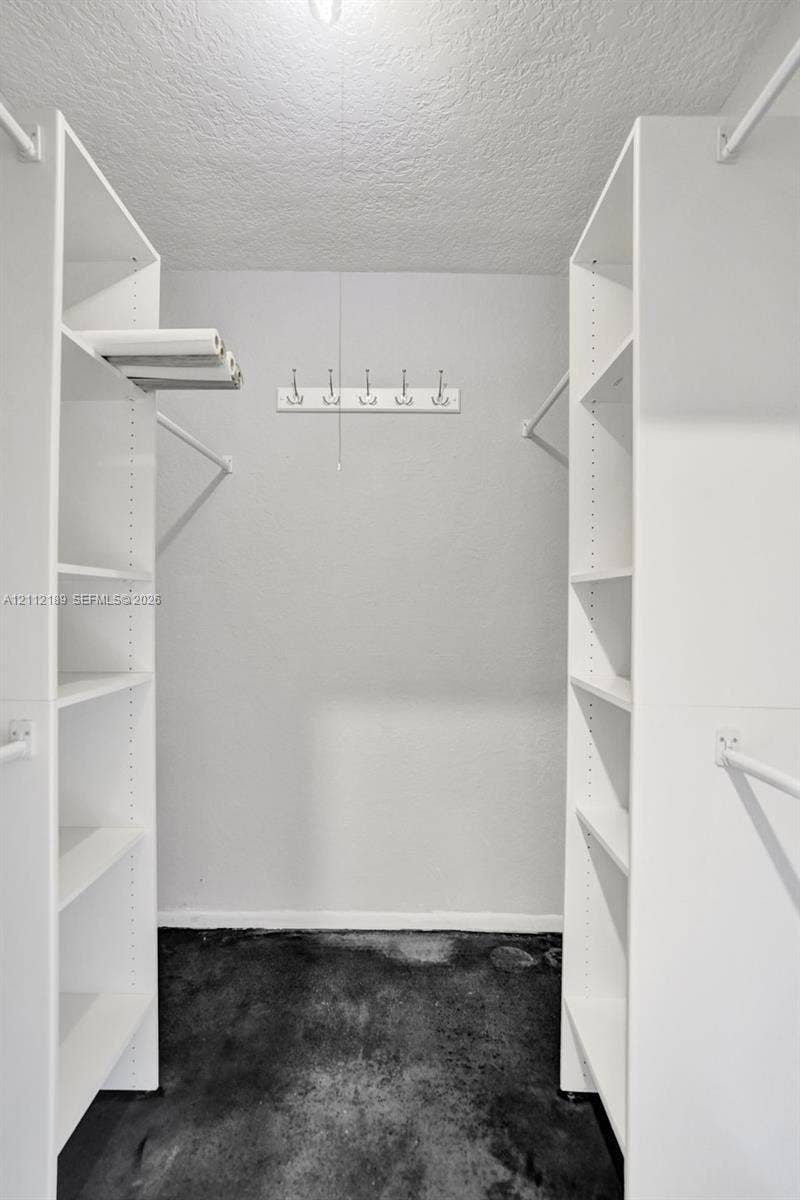 5161 SW 7th Court, #0, Margate, Margate, FL 33068 Walk-in closet featuring white built-in shelving, dual hanging rods, and a wall-mounted hook rack
