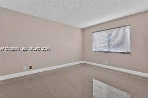 440 Lakeview Drive, #103, Weston, Weston, FL 33326 Neutral-toned room featuring tiled flooring, soft-hued walls, and horizontal window blinds