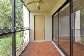 440 Lakeview Drive, #103, Weston, Weston, FL 33326 Screen-enclosed patio featuring tile flooring, a ceiling-mounted fan, and glass sliding doors