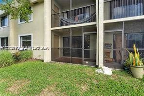 440 Lakeview Drive, #103, Weston, Weston, FL 33326 Multi-level exterior featuring screened-in patios, dark-framed sliding glass doors, horizontal metal railings, and stucco siding