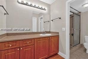 440 Lakeview Drive, #103, Weston, Weston, FL 33326 Bathroom featuring a wood-finish vanity with a neutral countertop, recessed sink, integrated multi-bulb vanity lighting, and a glass-enclosed shower