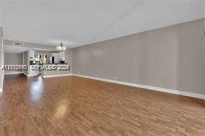 440 Lakeview Drive, #103, Weston, Weston, FL 33326 Open-concept interior featuring wood-finish flooring, neutral wall tones, and a breakfast bar