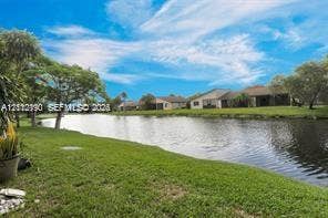 440 Lakeview Drive, #103, Weston, Weston, FL 33326 Waterfront property featuring a canal, expansive lawn, and mature trees
