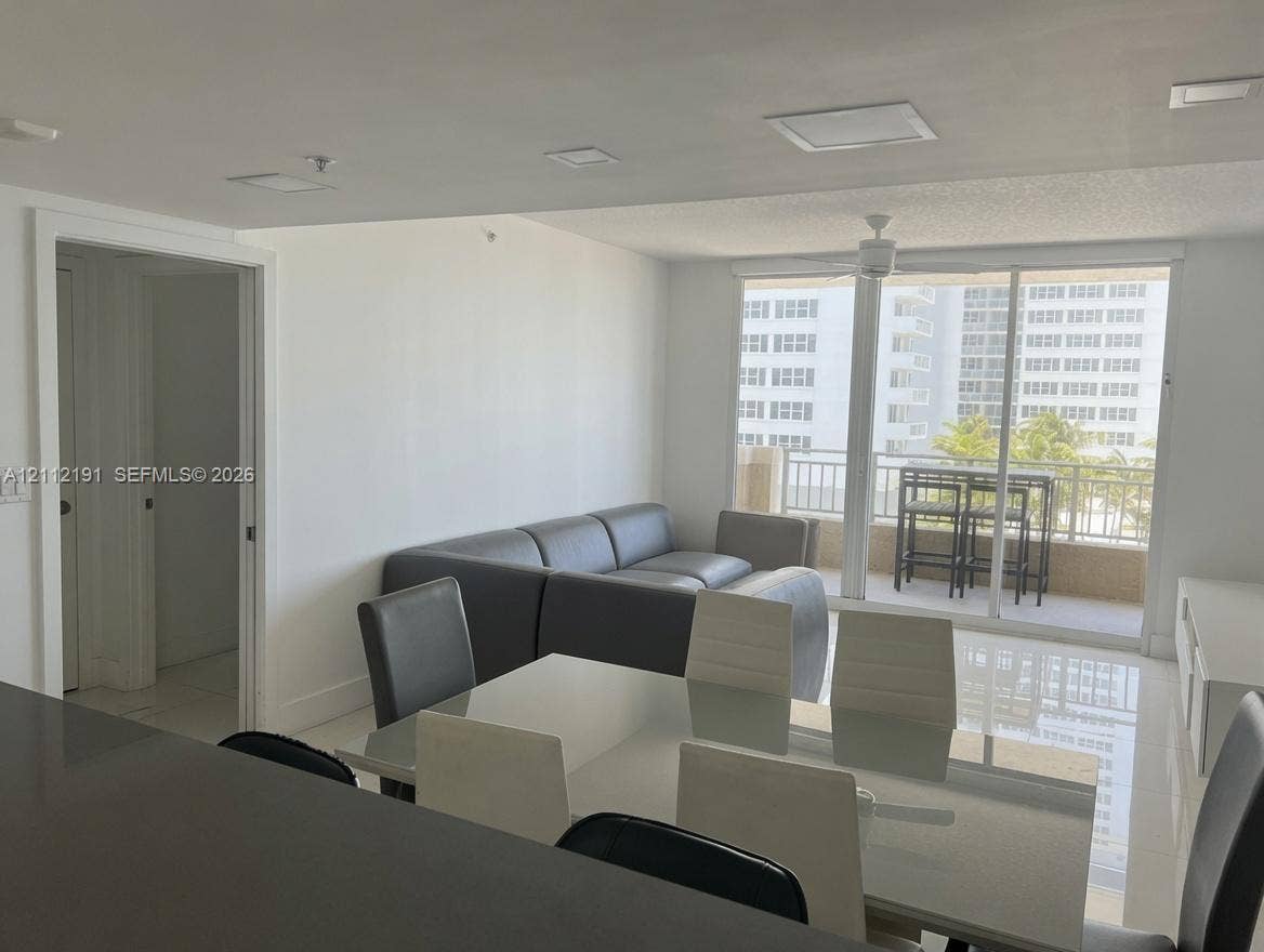 Interior space featuring large-format tile flooring, recessed LED lighting, and a sliding glass door with balcony access