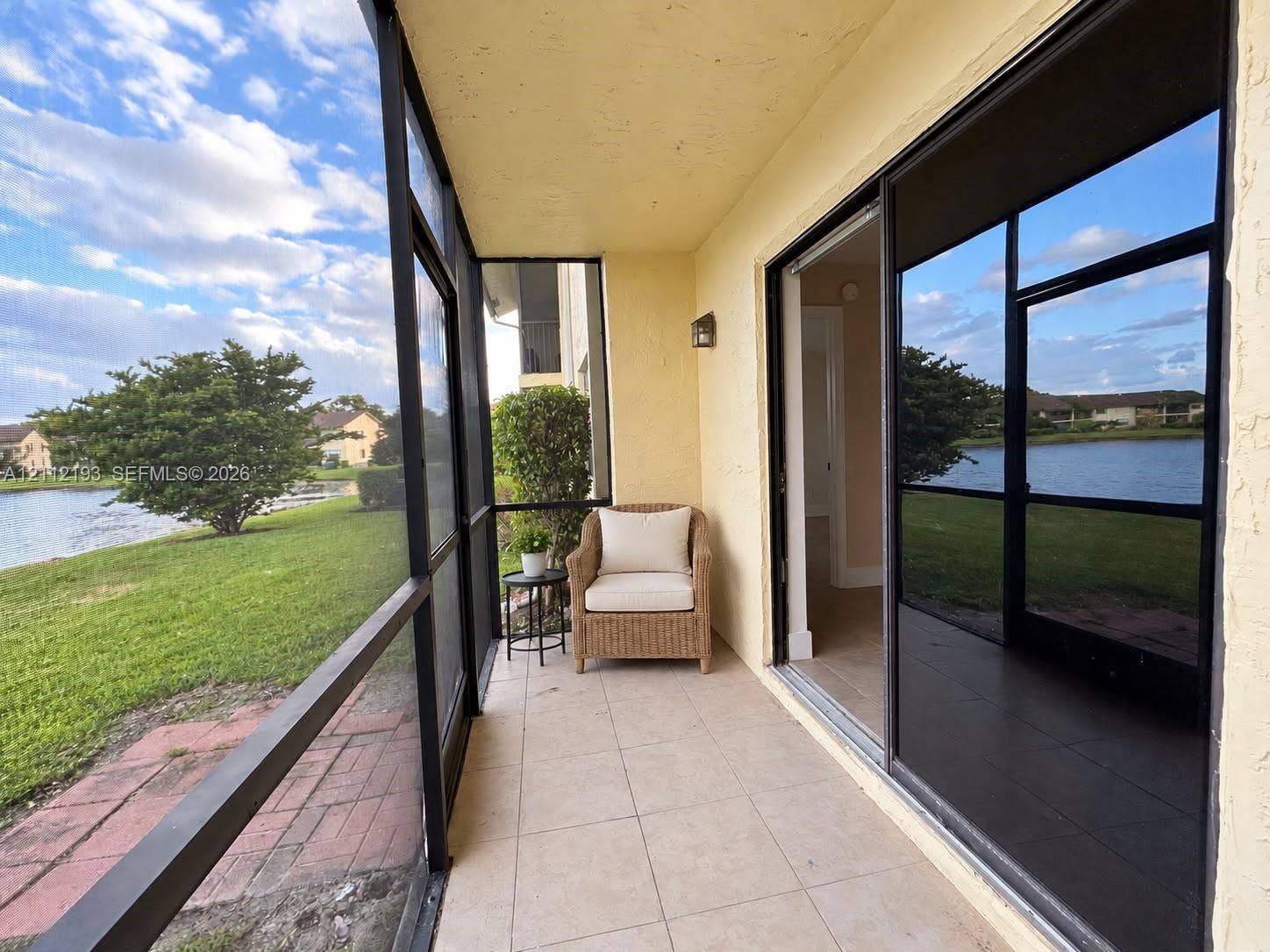 10013 Winding Lake Road, #106, Sunrise, Sunrise, FL 33351 Screen-enclosed patio featuring tile flooring, metal framing, and sliding glass doors