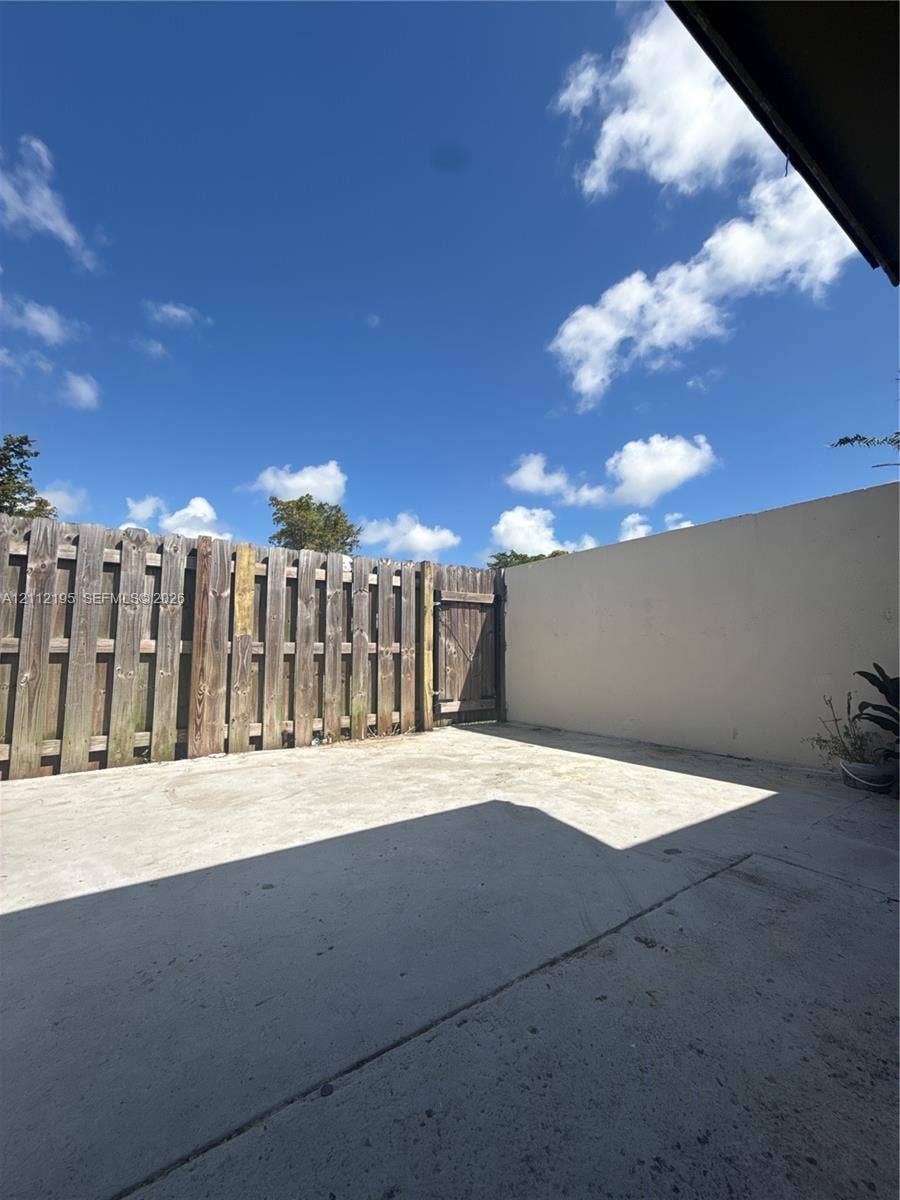 11745 SW 122nd Place, #11745, Miami, Miami, FL 33186 Private patio featuring concrete flooring, a wooden privacy fence, and an integrated gate