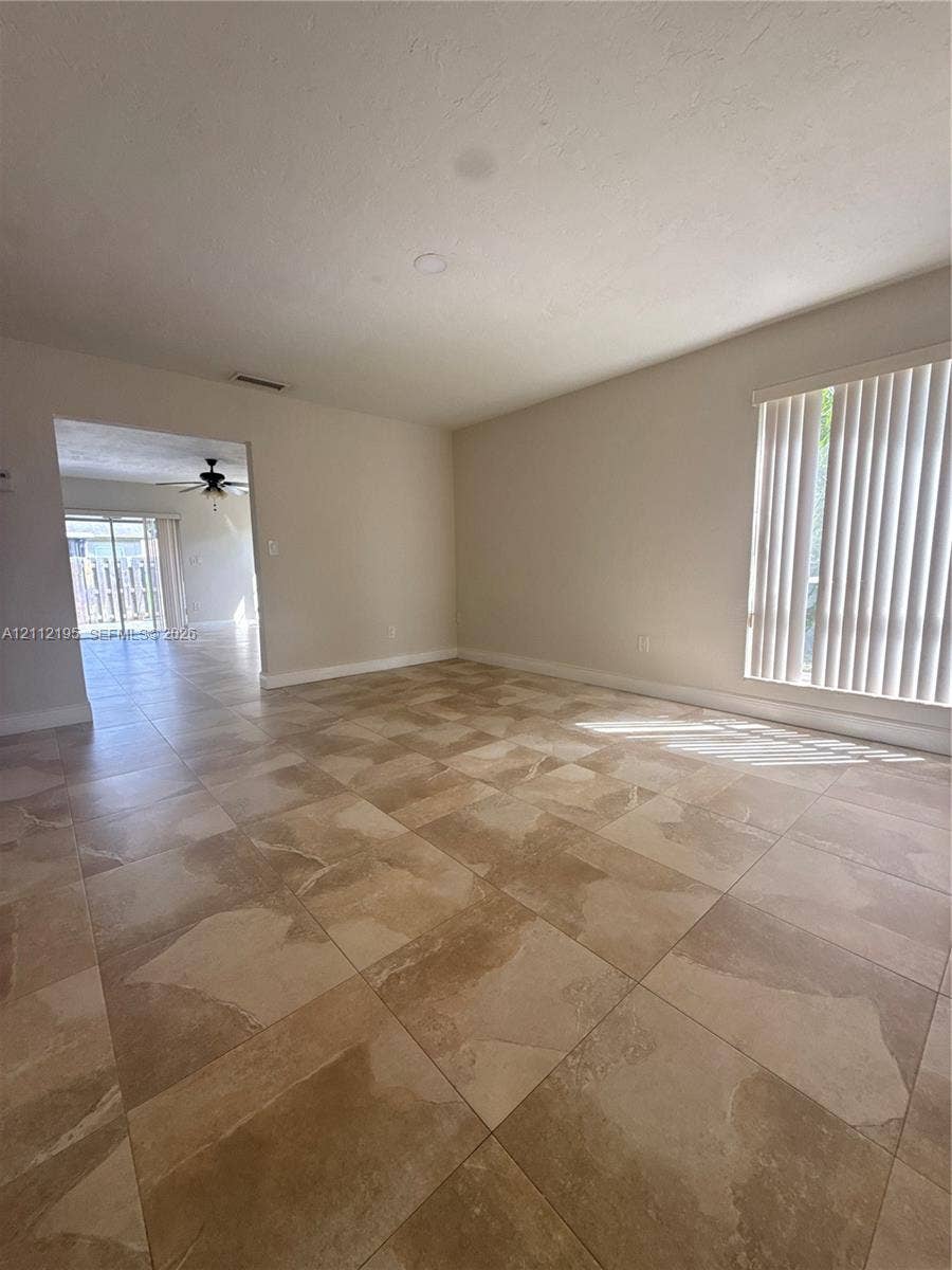 11745 SW 122nd Place, #11745, Miami, Miami, FL 33186 Large-format tile flooring, neutral wall paint, and vertical window blinds
