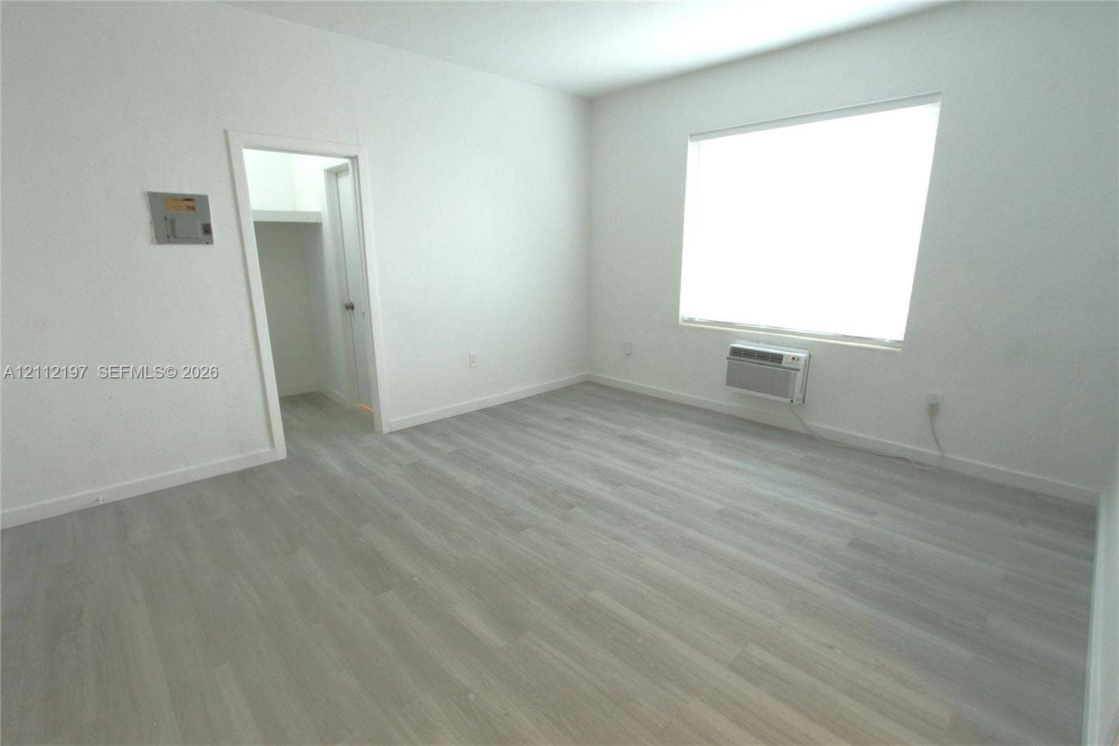 1115 Euclid Avenue, #15, Miami Beach, Miami Beach, FL 33139 Interior space featuring wood-finish flooring, a large window, and an attached wall-mounted heating and cooling unit