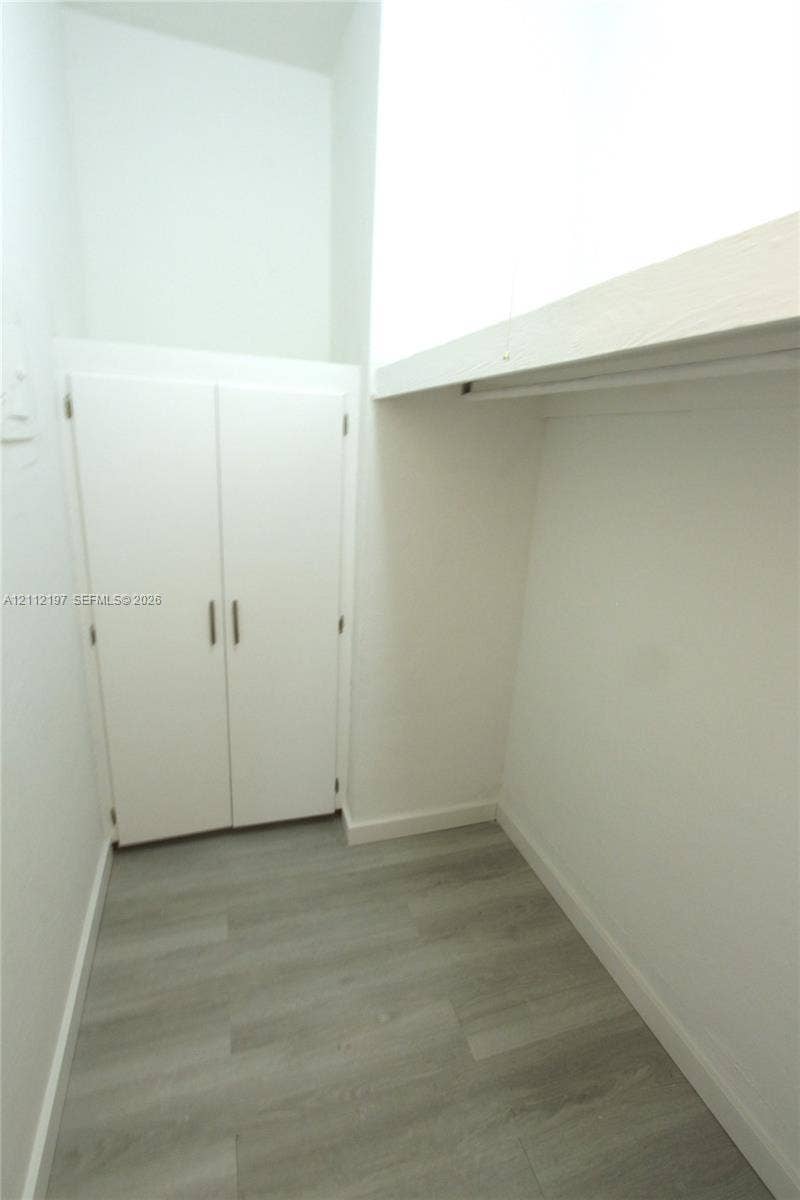 1115 Euclid Avenue, #15, Miami Beach, Miami Beach, FL 33139 Storage area featuring wood-finish flooring, a double-door closet, and an overhead built-in shelf