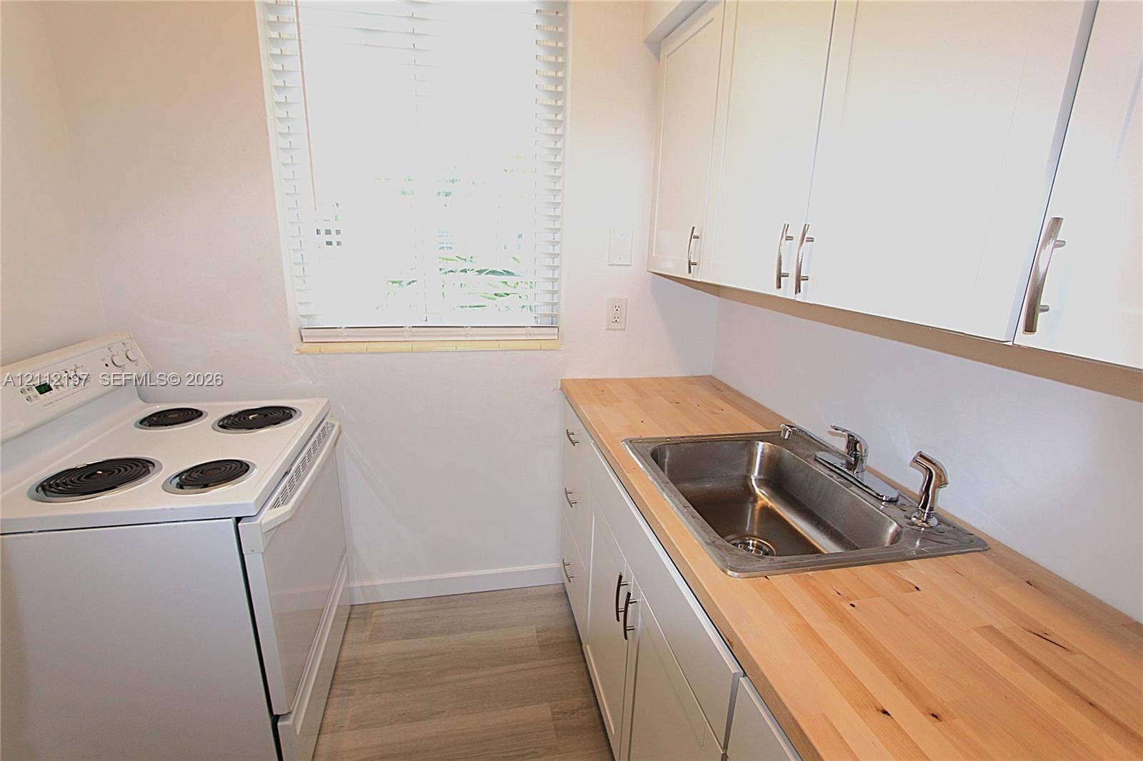 1115 Euclid Avenue, #15, Miami Beach, Miami Beach, FL 33139 Kitchen featuring white cabinetry, wood-finish countertops, stainless steel sink with a side sprayer, white electric range, and wood-finish flooring