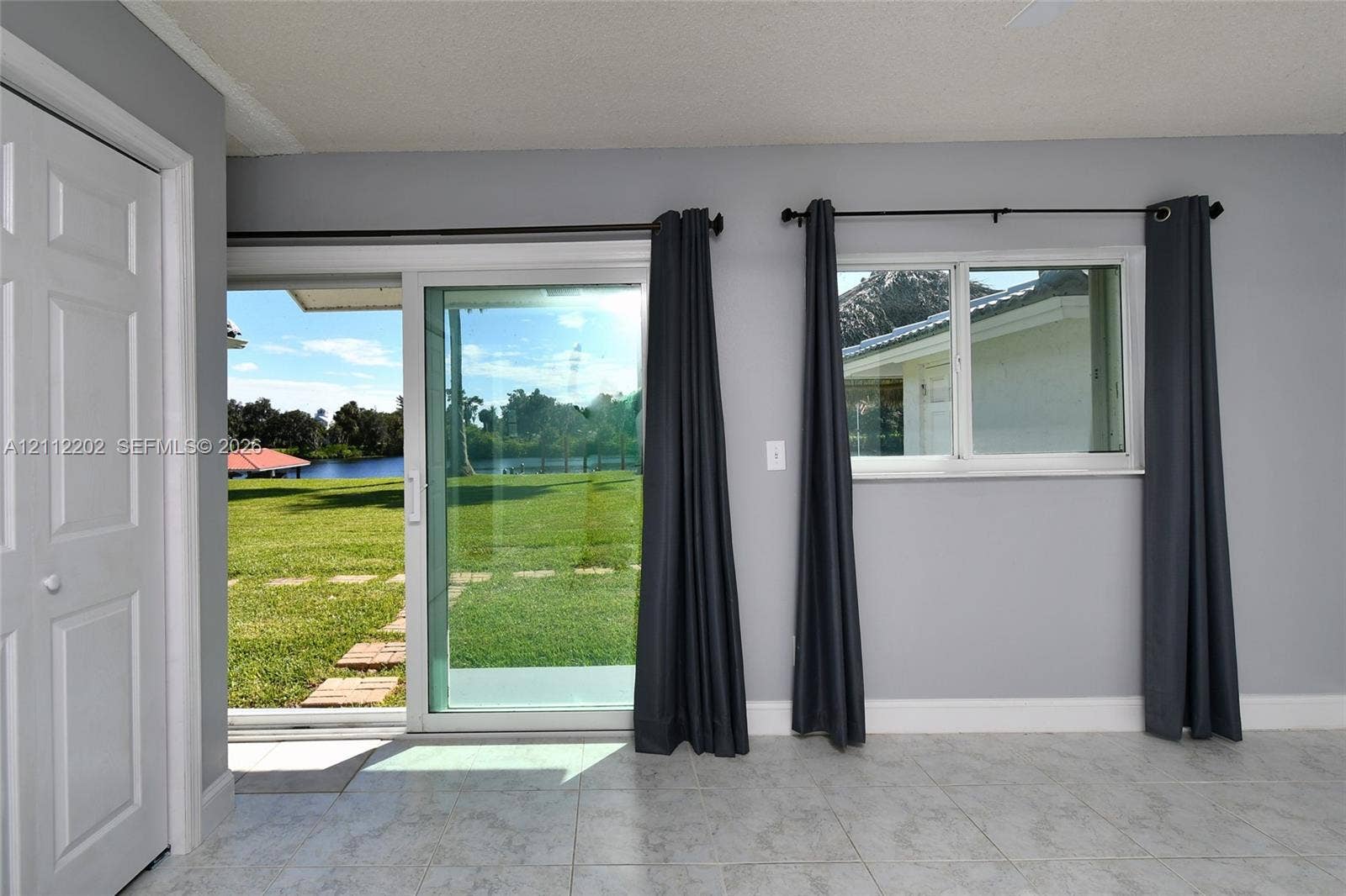 3233 Shell Lane, Labelle, FL 33935 Sliding glass door, single-hung window, light-toned tile flooring, and neutral grey wall paint