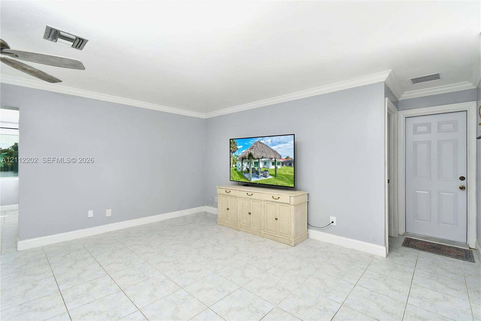 3233 Shell Lane, Labelle, FL 33935 Interior space featuring light-toned tile flooring, crown molding, and a ceiling fan with integrated lighting