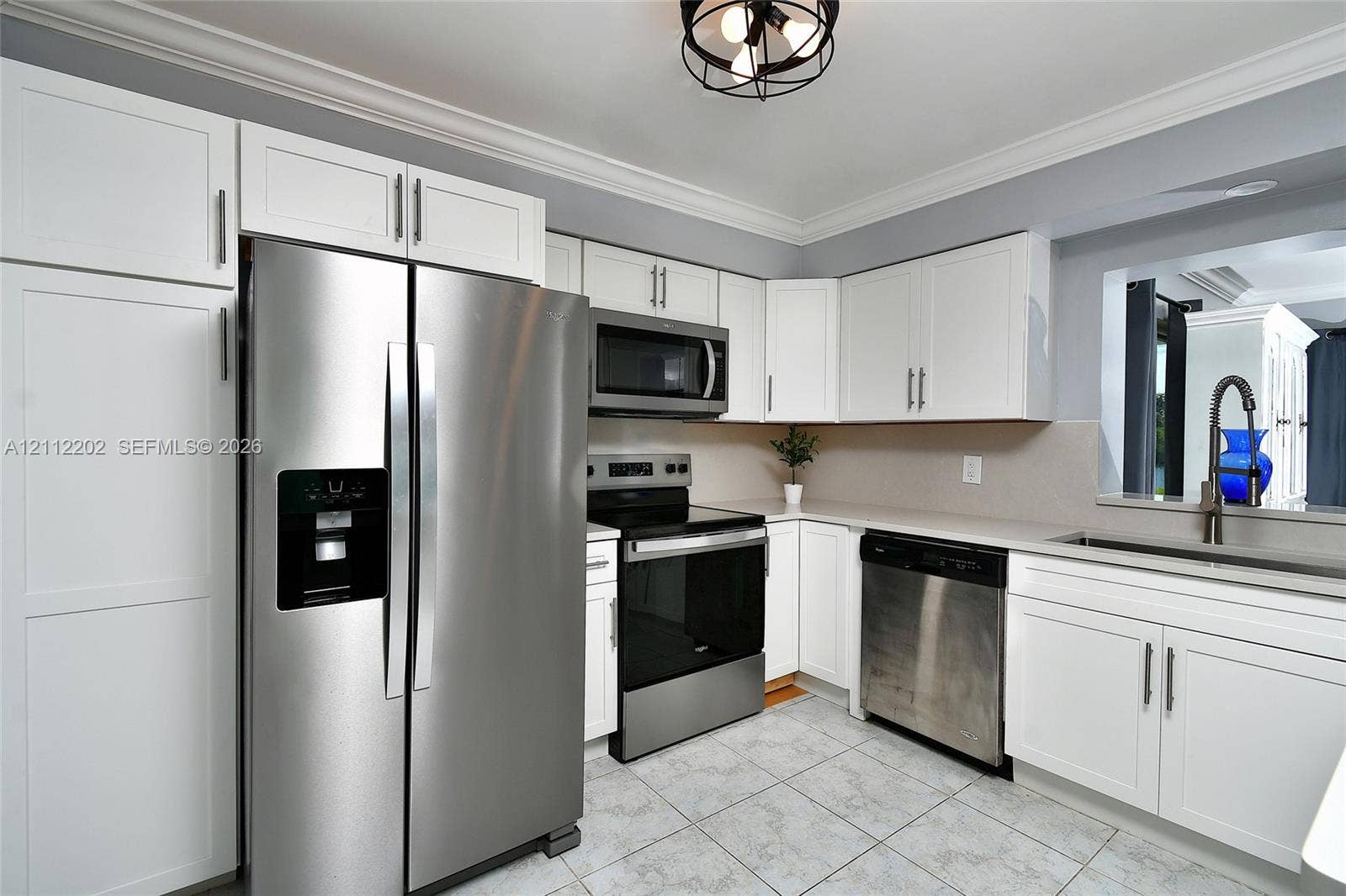 3233 Shell Lane, Labelle, FL 33935 Kitchen featuring white cabinetry, stainless steel appliances, tile flooring, stone-finish countertops, and a ceiling-mounted industrial-style light fixture