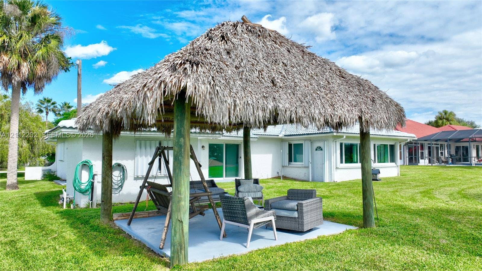 3233 Shell Lane, Labelle, FL 33935 Outdoor pavilion featuring a thatched roof, timber support posts, and a concrete patio floor