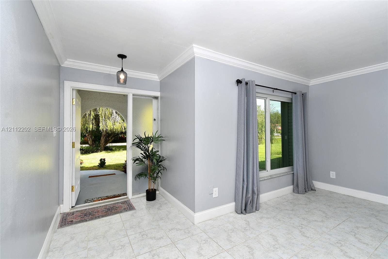 3233 Shell Lane, Labelle, FL 33935 Foyer featuring tile flooring, crown molding, and a decorative pendant light