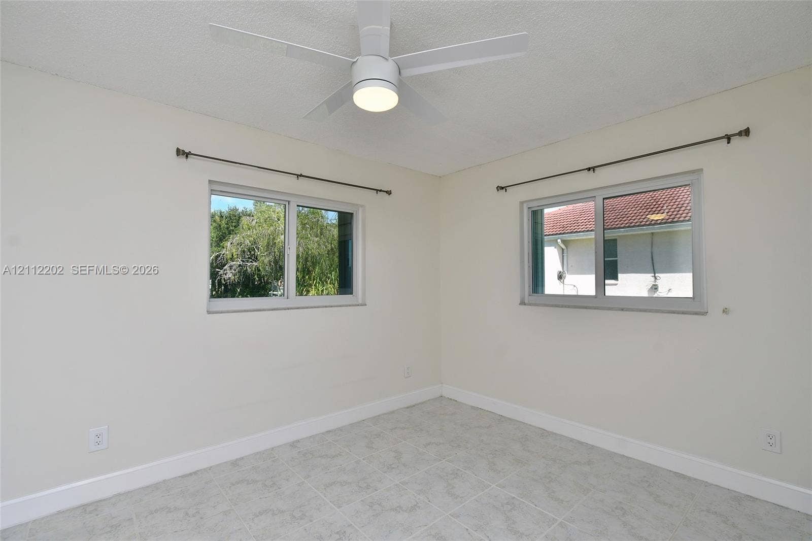 3233 Shell Lane, Labelle, FL 33935 Room featuring neutral wall paint, tile flooring, and a ceiling-mounted light fixture with a fan