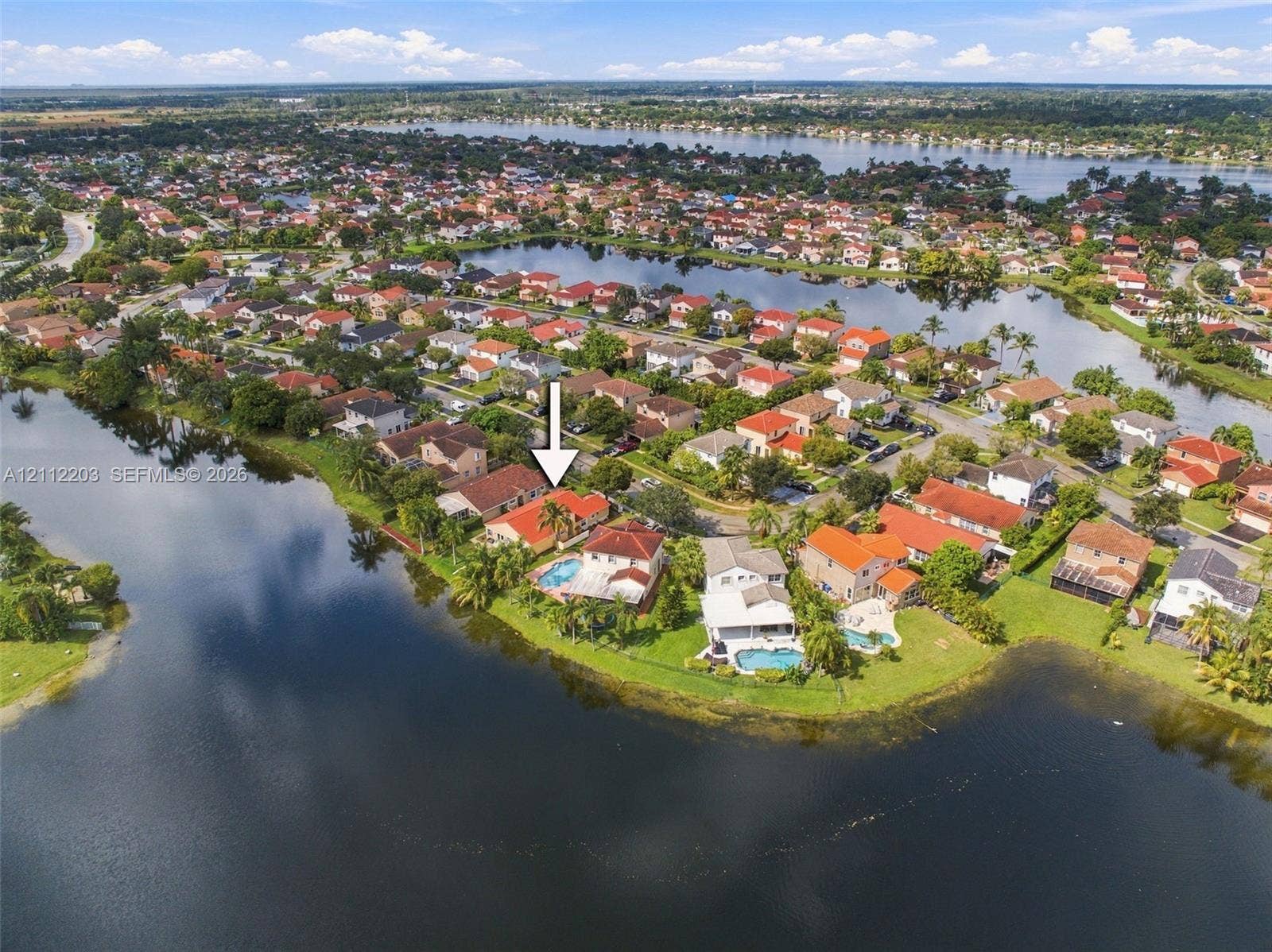 Waterfront property featuring a private swimming pool, concrete tile roof, and a screened-in lanai