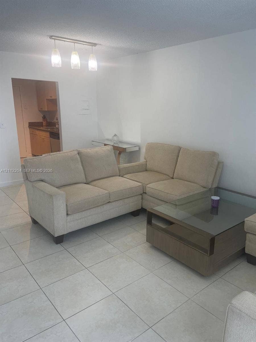 2020 NE 135th Street, #910, North Miami, North Miami, FL 33181 Neutral-toned tile flooring and three-pendant track lighting fixture