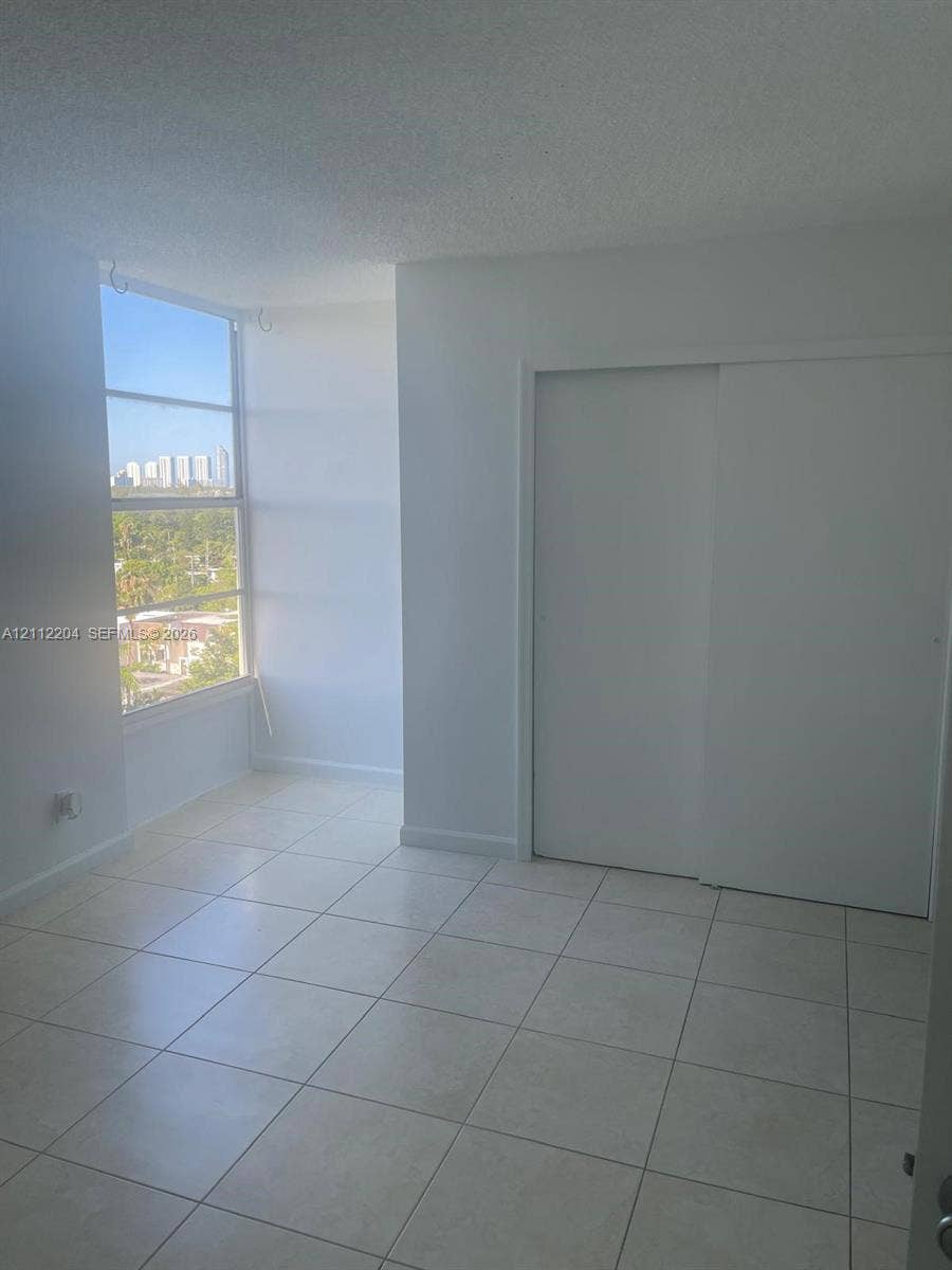2020 NE 135th Street, #910, North Miami, North Miami, FL 33181 Floor-to-ceiling multi-panel windows, ceramic tile flooring, and a built-in sliding door closet