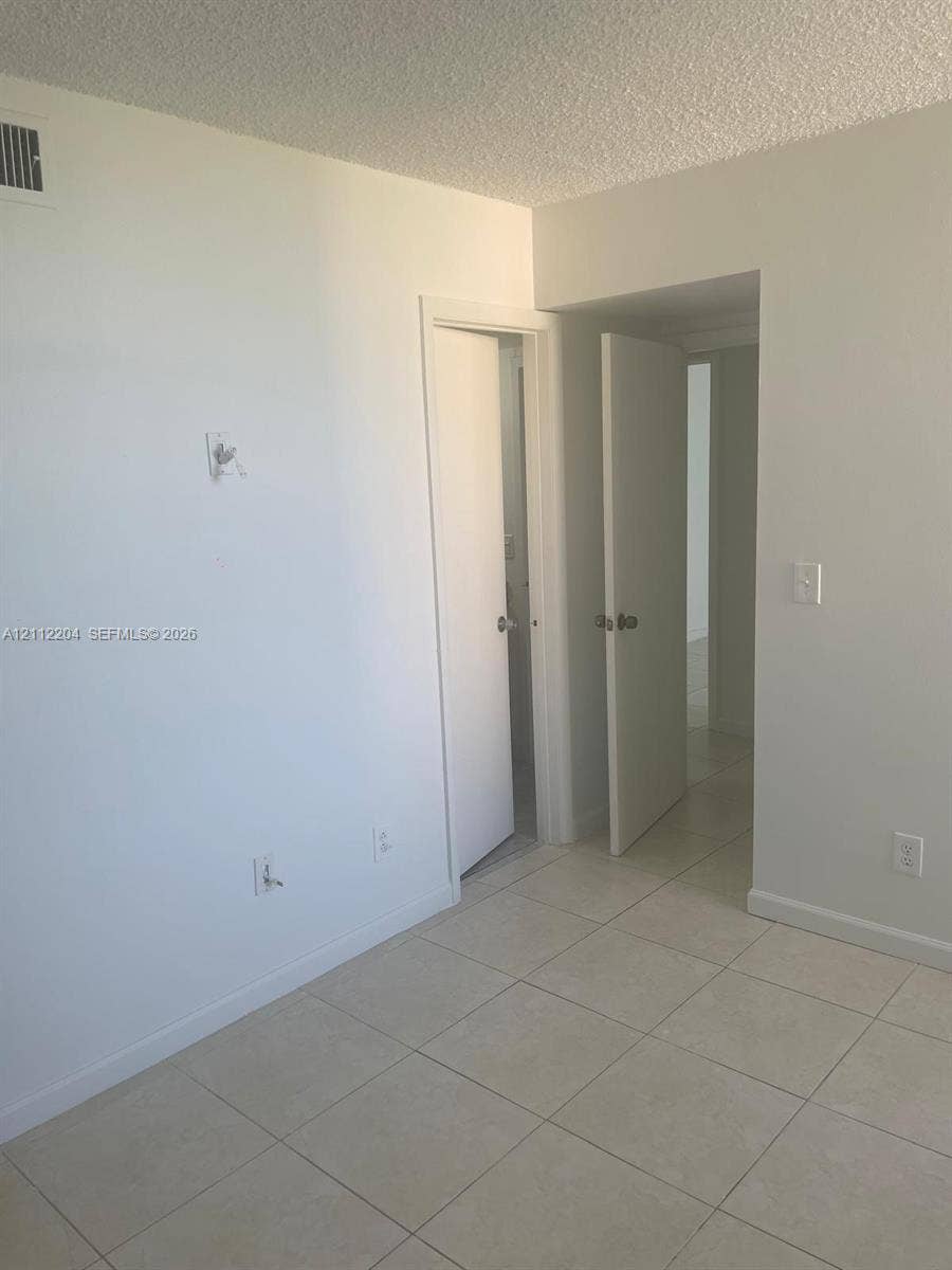 2020 NE 135th Street, #910, North Miami, North Miami, FL 33181 Interior room featuring neutral wall paint, tile flooring, and solid-core doors
