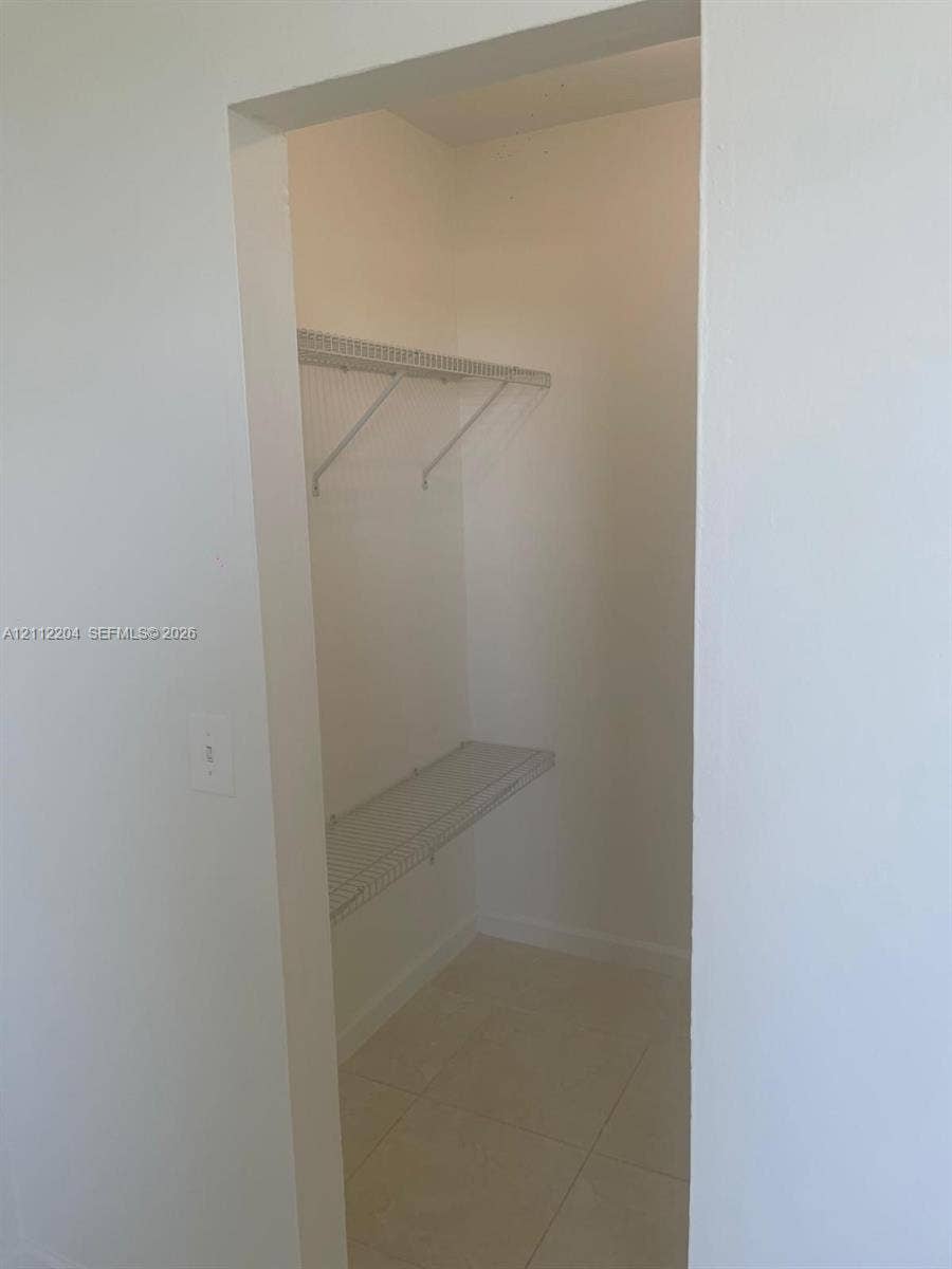 2020 NE 135th Street, #910, North Miami, North Miami, FL 33181 Walk-in closet featuring light-colored tile flooring and two-tier wire shelving